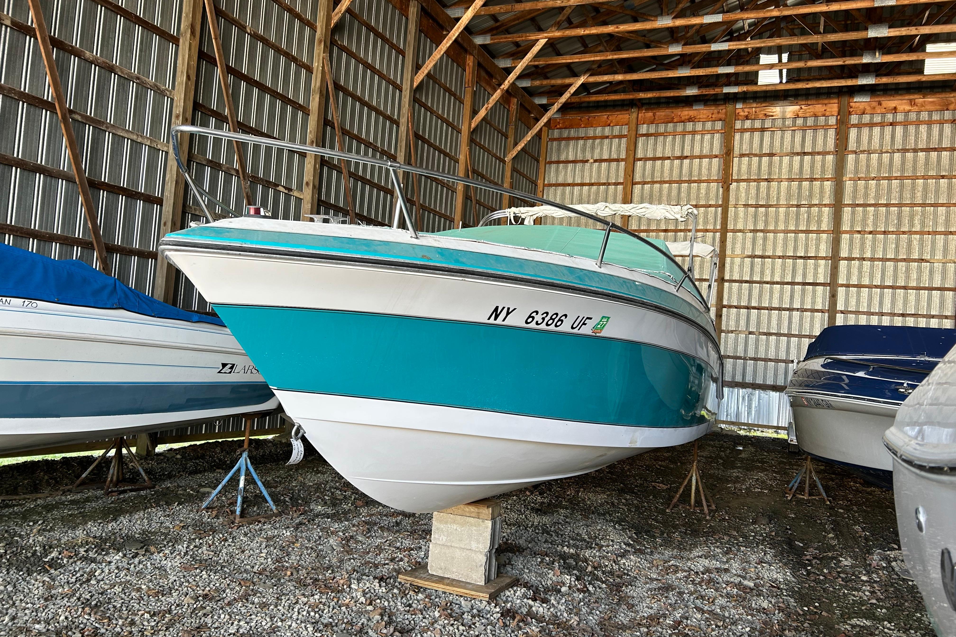 1991 Wellcraft 232 Eclipse boat stored in a metal shed.