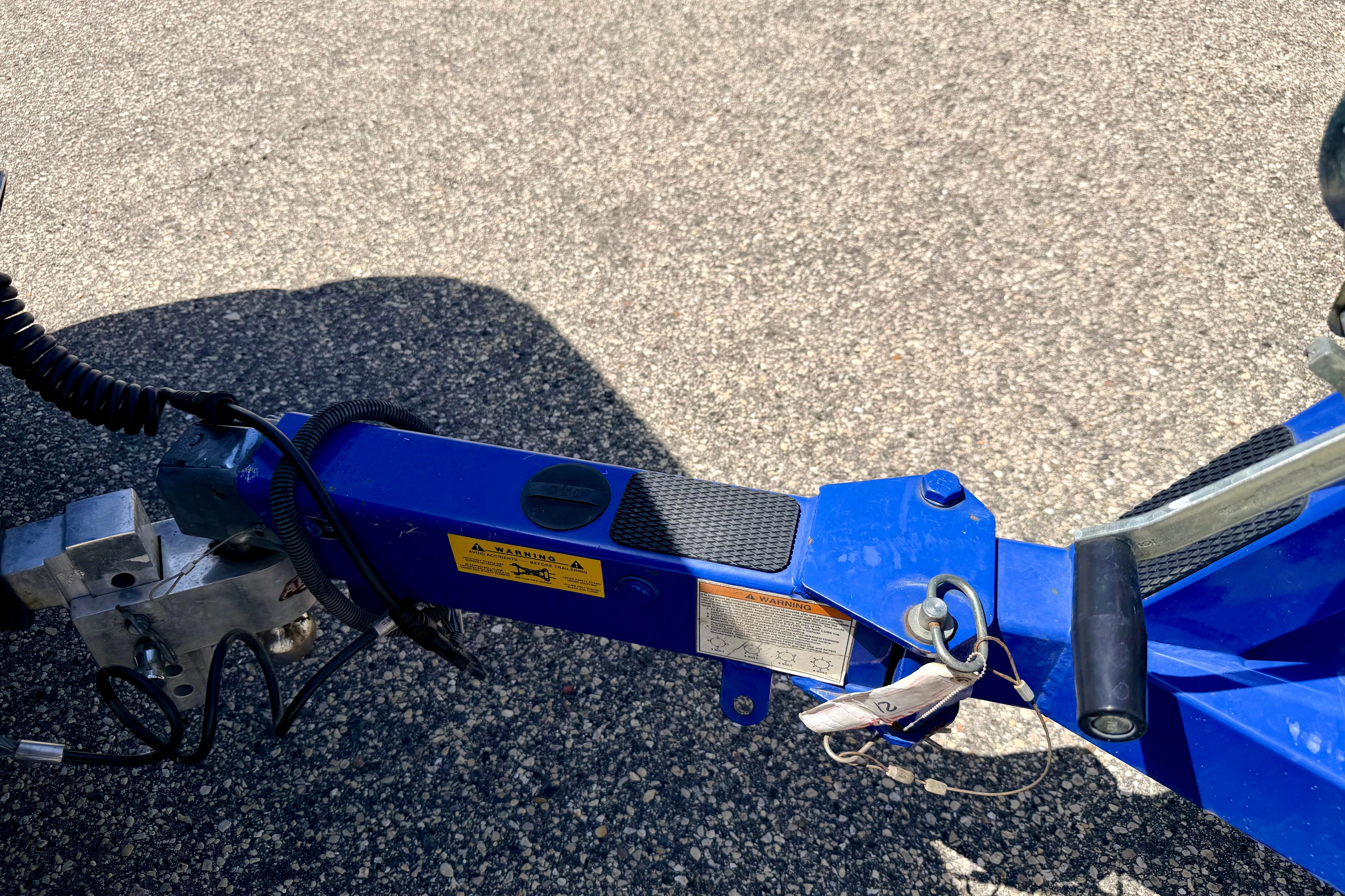 Trailer hitch of a 2008 Moomba Outback V boat on asphalt surface.