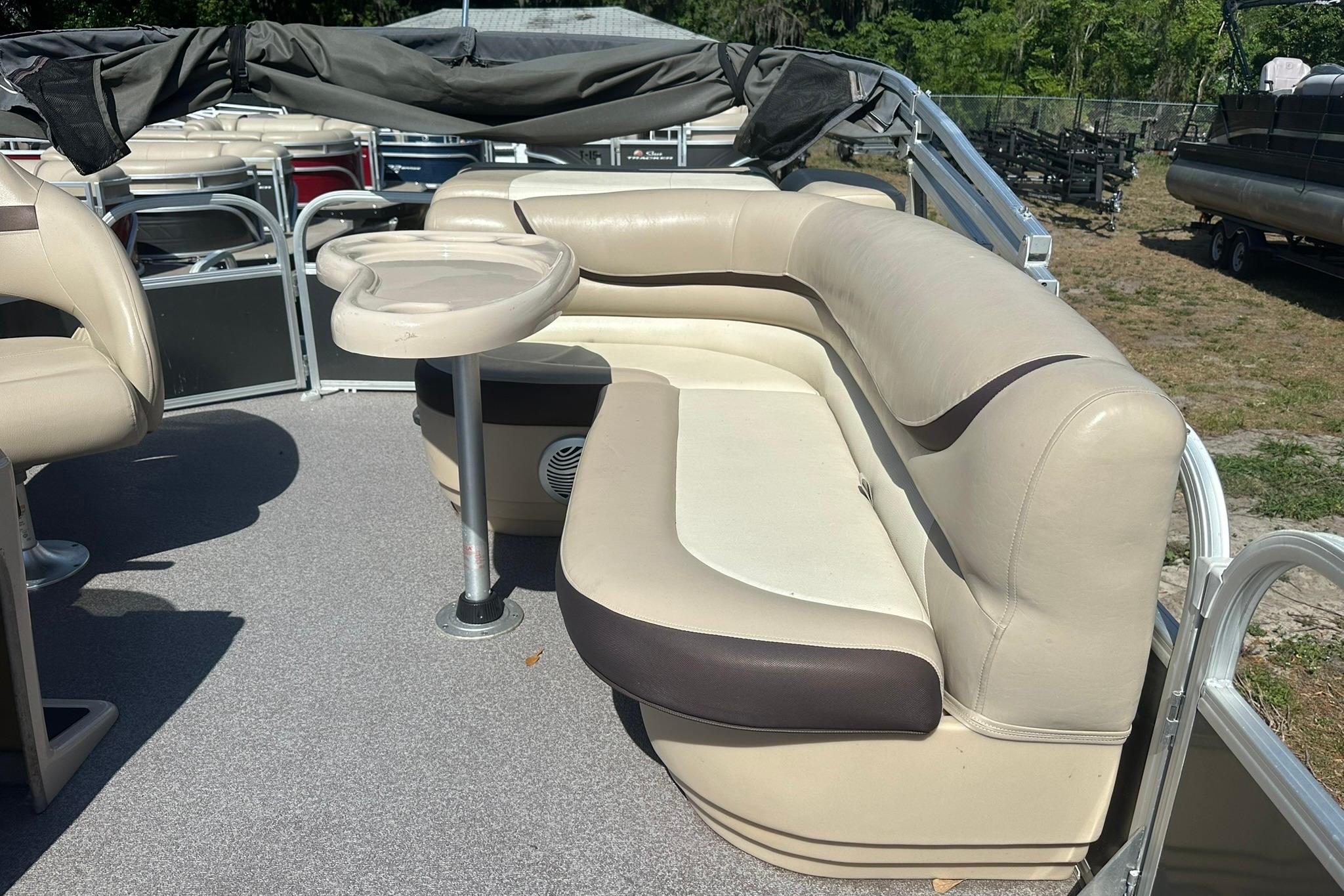 2016 SUNTRACKER Party Barge 20 interior with beige seating and table on deck.