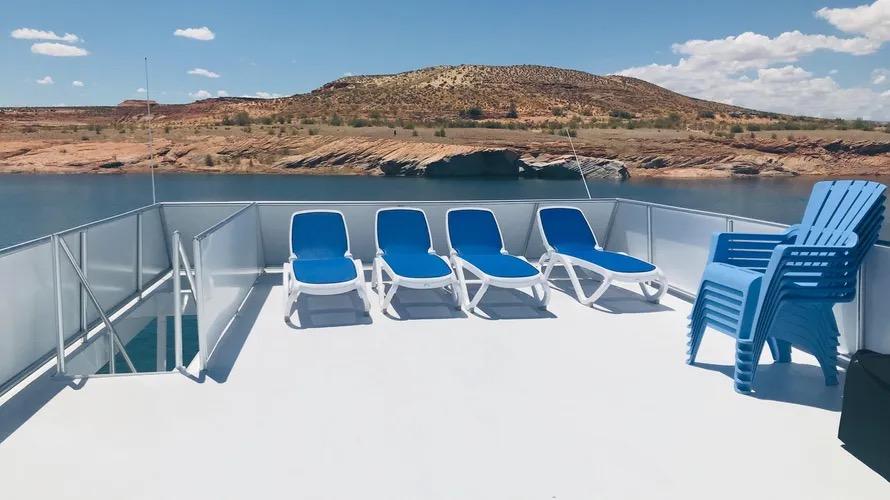 Deck of Adonia Inspiration Trip #14, 2019, with blue lounge chairs and scenic water view.