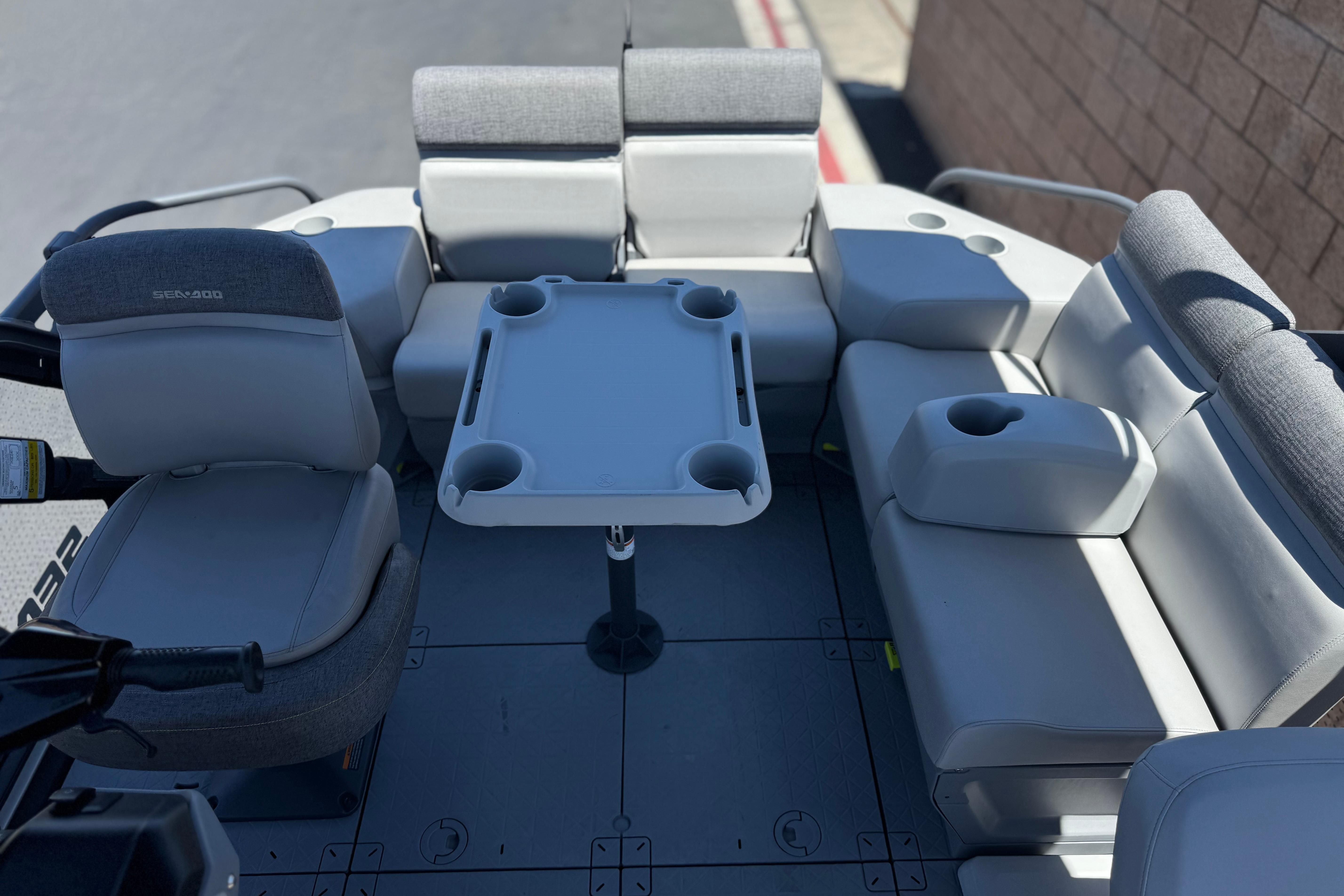 2024 Sea-Doo Switch Compact interior with seating and table, featuring cup holders.