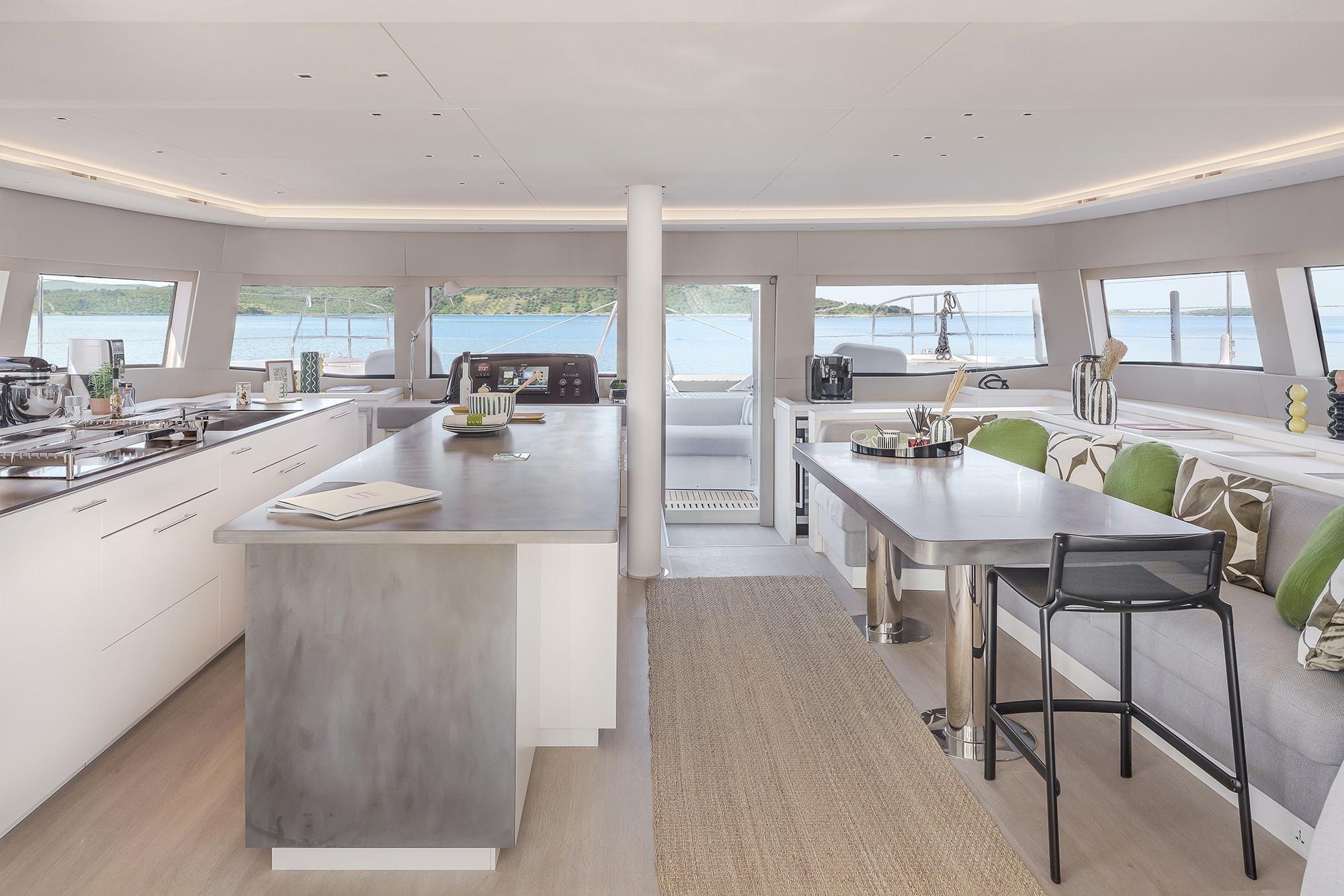 Luxurious interior of 2024 Lagoon SIXTY 5 yacht with modern kitchen and dining area.