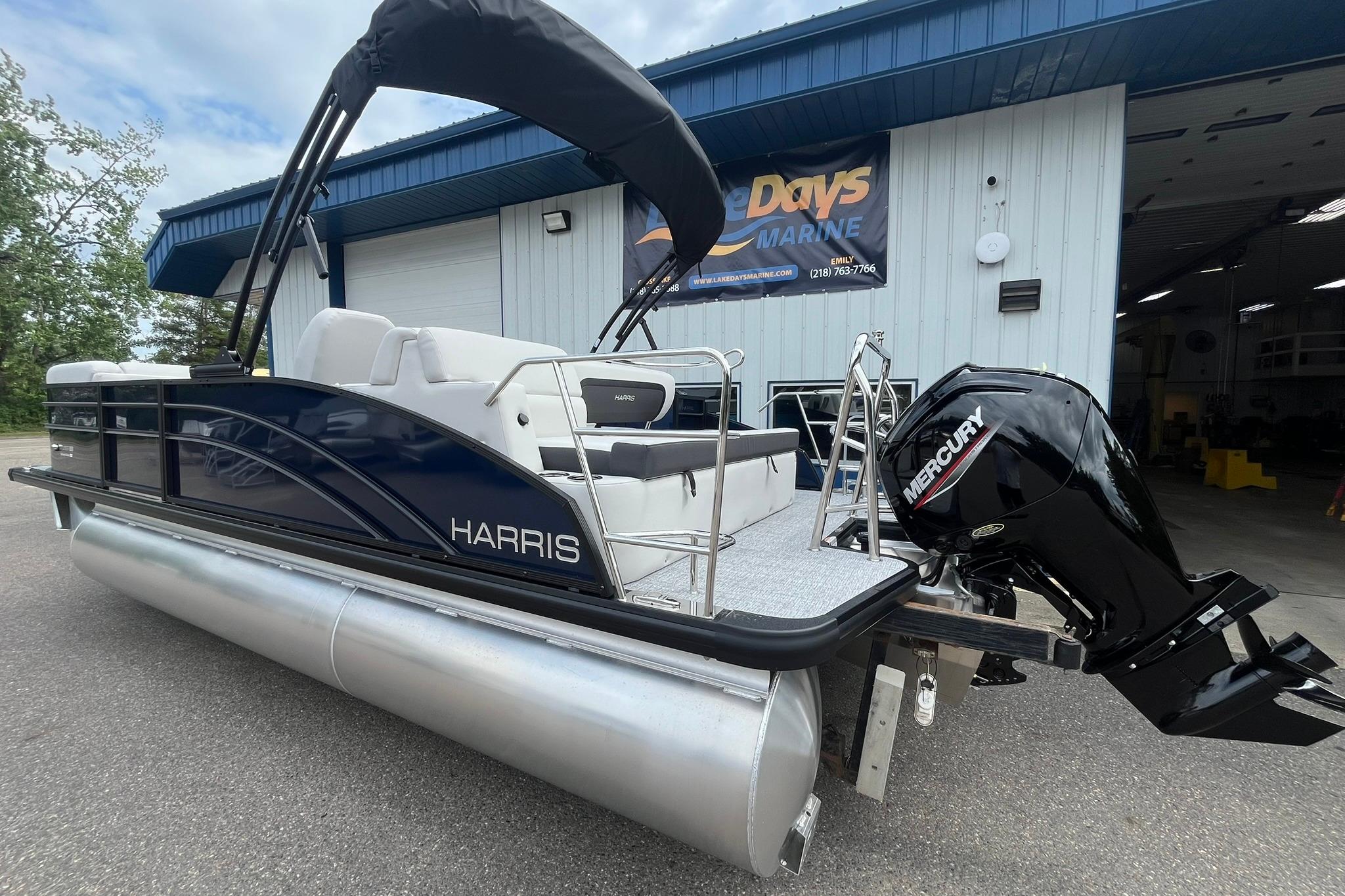 2026 Harris Cruiser 210 pontoon boat with Mercury engine at a marine dealership.