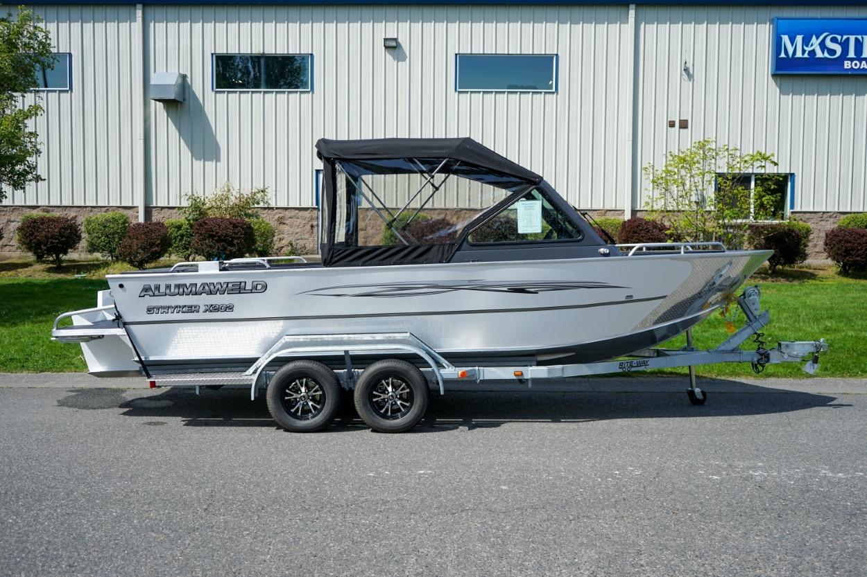 2026 Alumaweld X202 Stryker boat on trailer, parked outdoors near building.