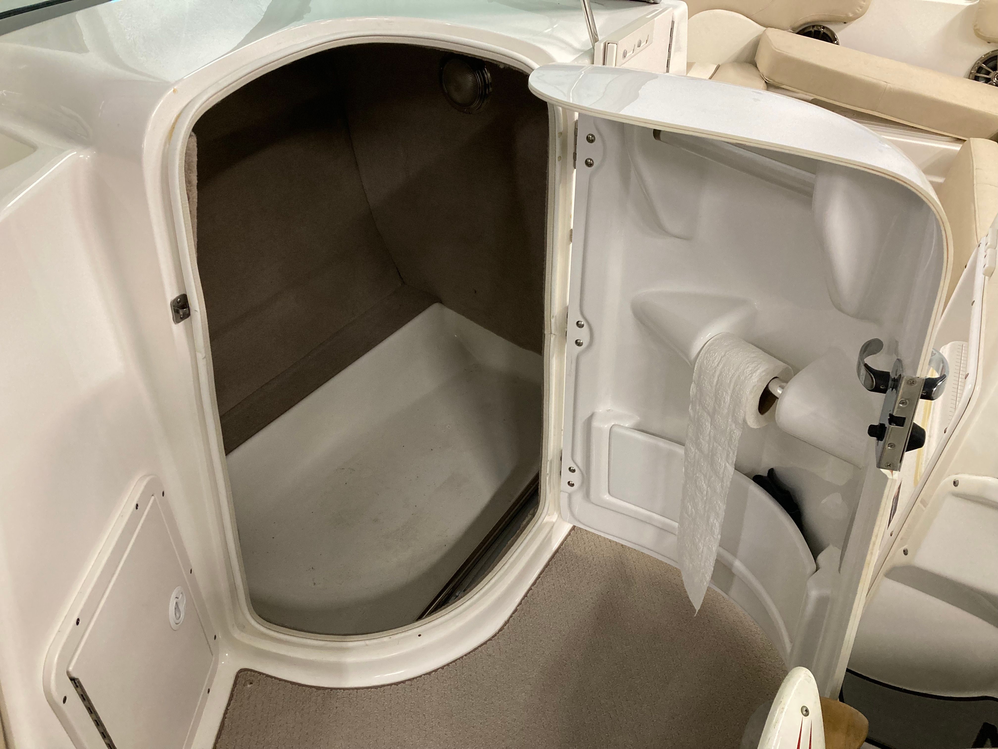 Interior view of a boat cabin with a toilet and storage space.
