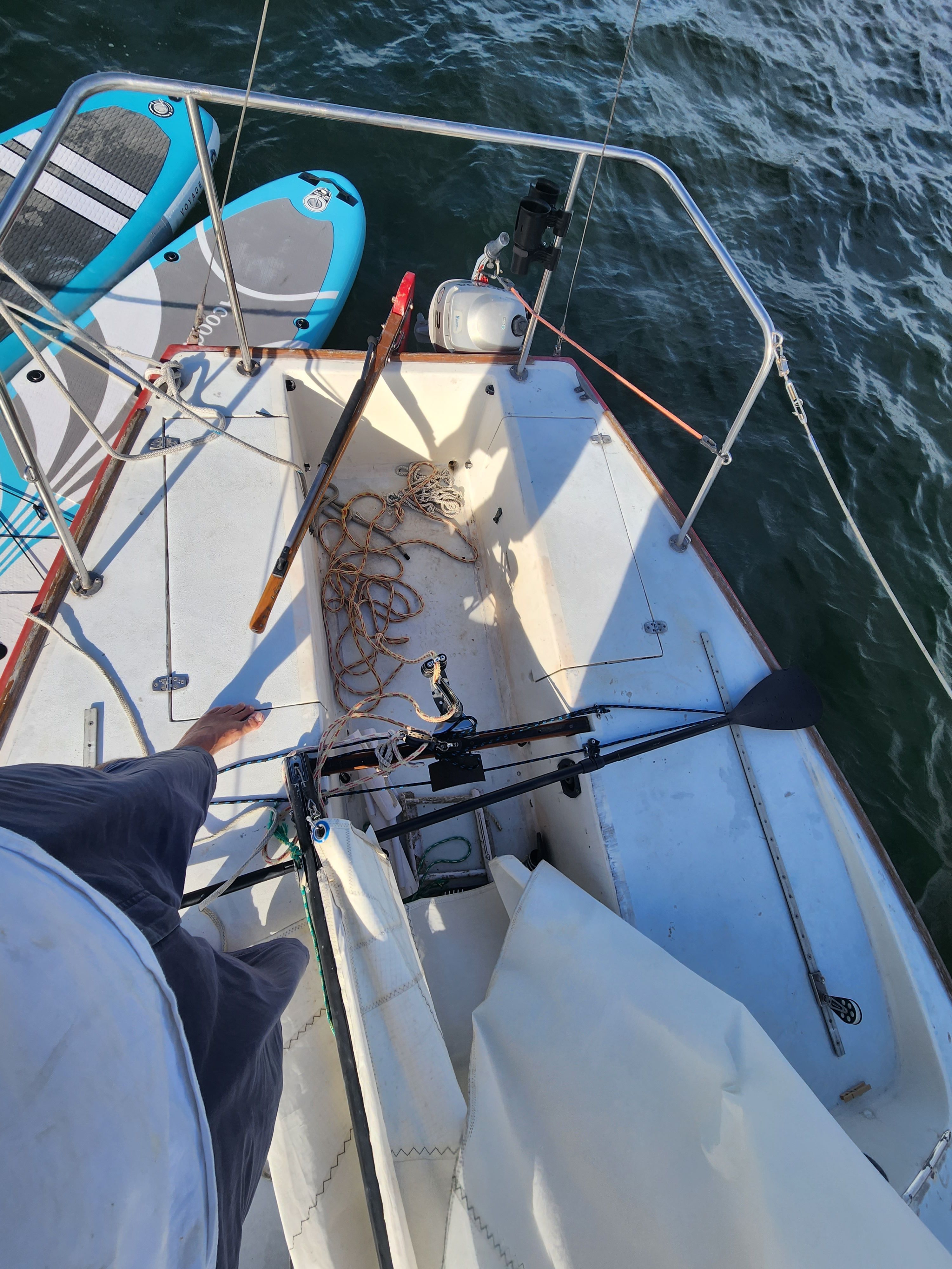 Deck of a 1978 J/24 sailboat with paddle and ropes.