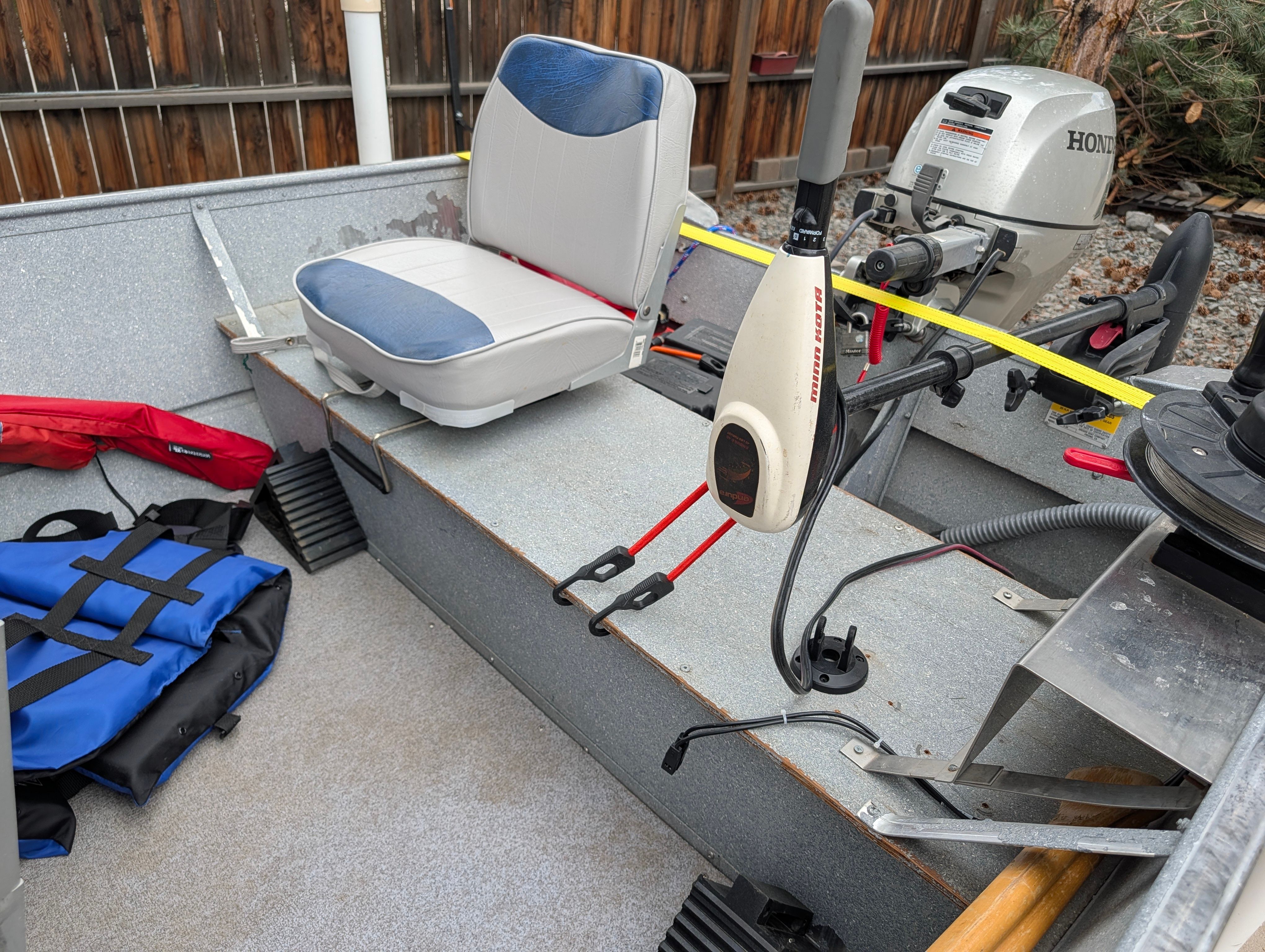 The image shows the interior of a boat with a seat and a Honda motor.