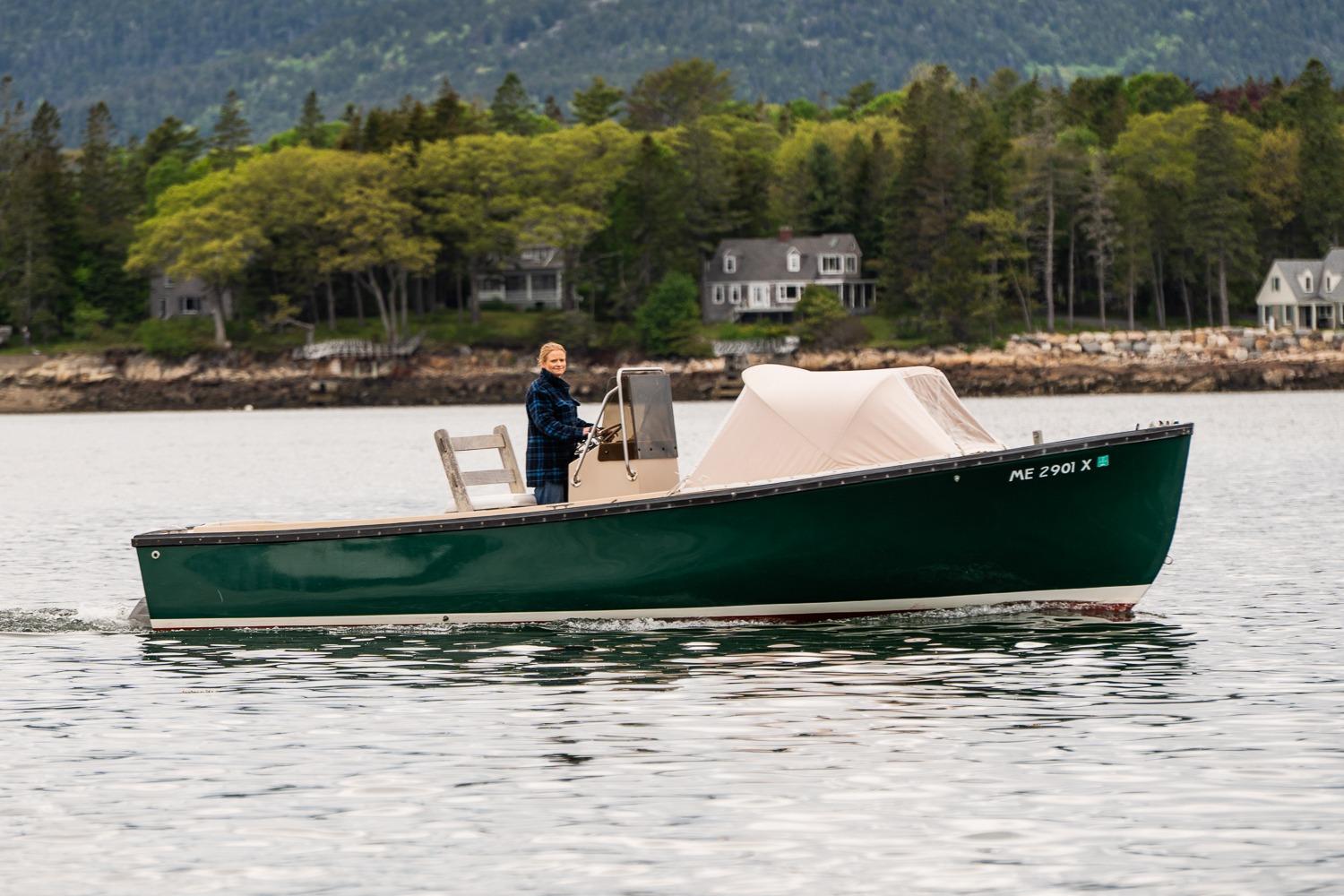 1989 Ellis 24 Open boat cruising on a scenic lake with forested shoreline.