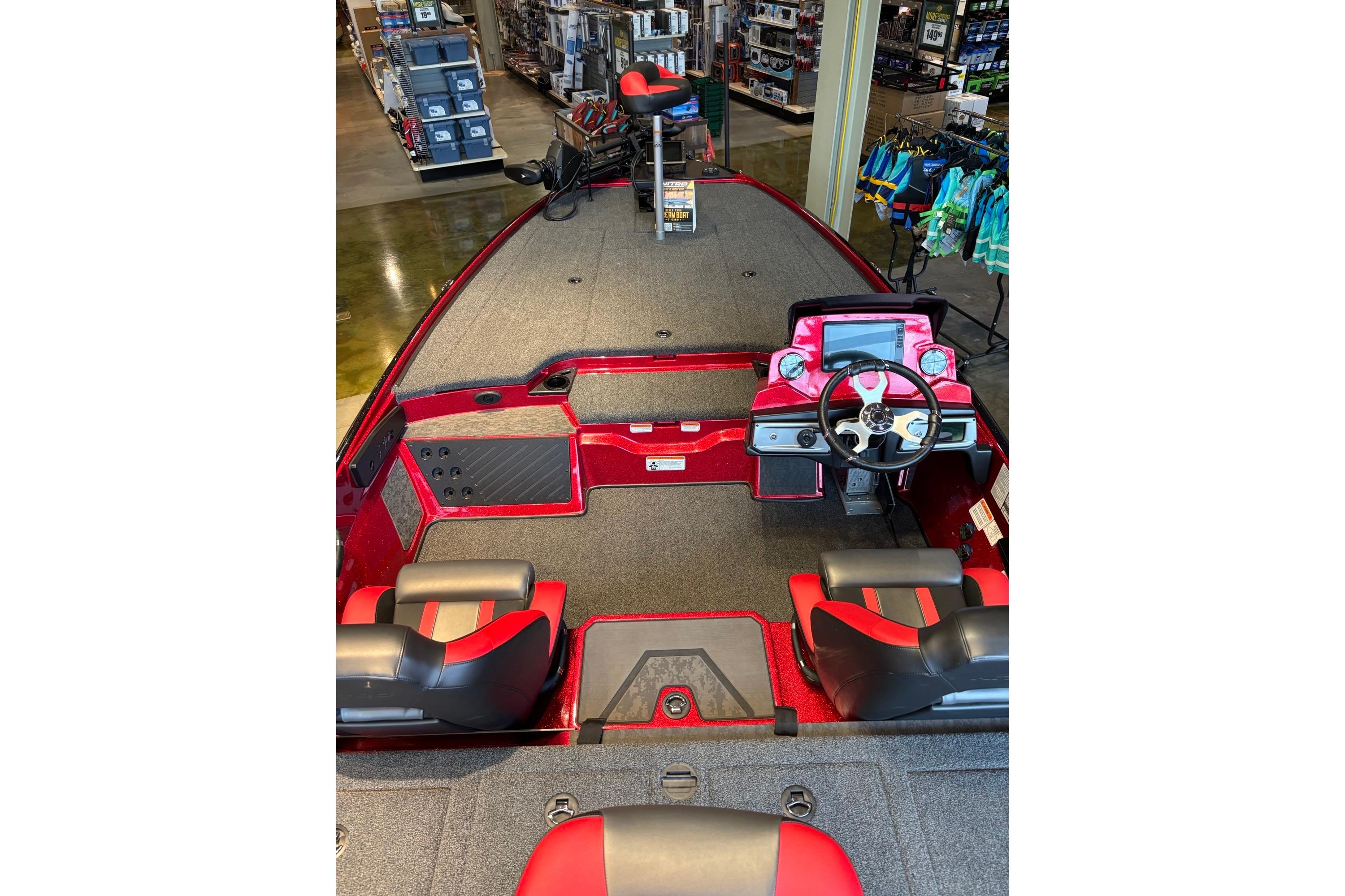 2026 Nitro Z20 XL Pro boat interior with red and black seating, steering console, and fishing gear.