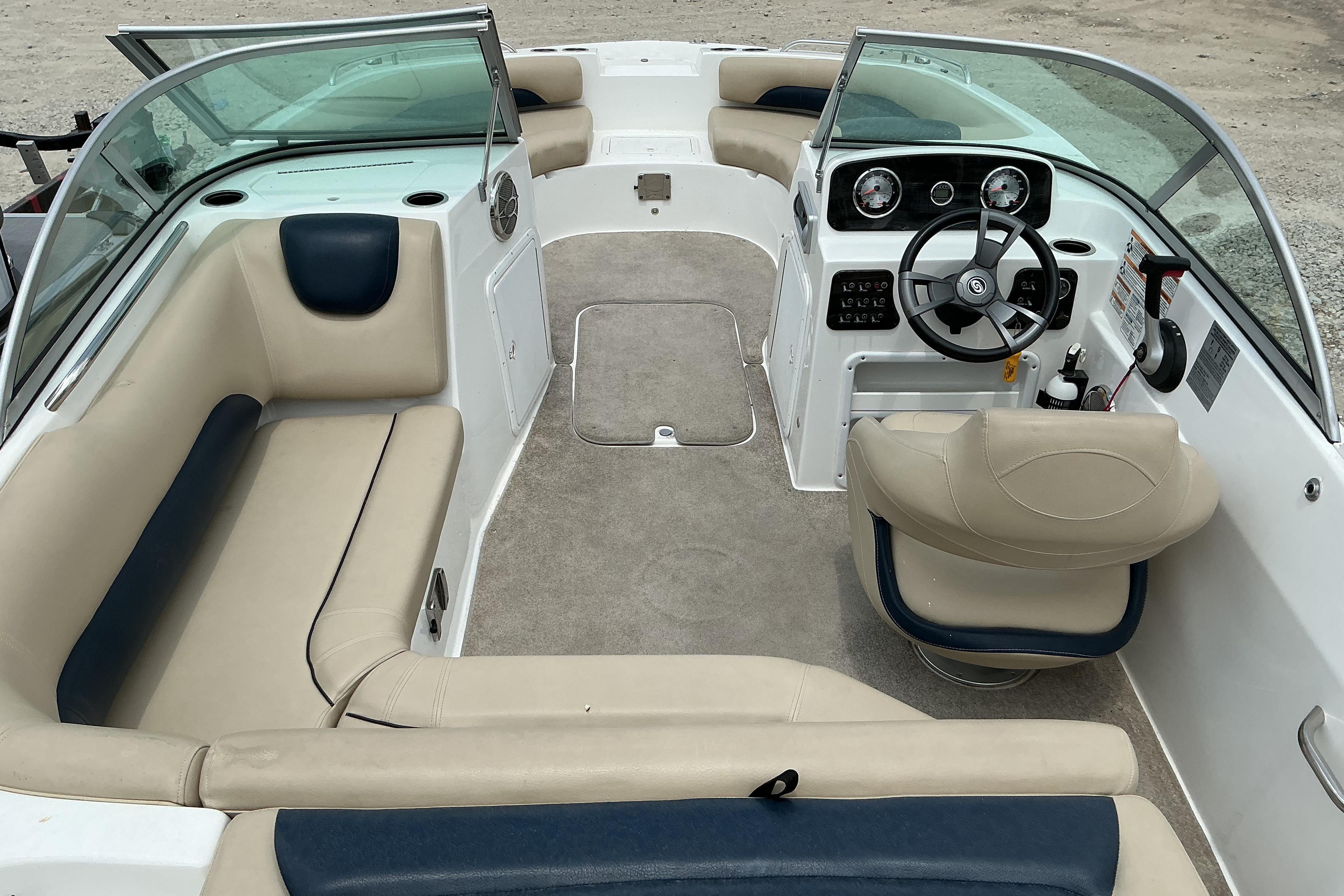 2015 Hurricane SunDeck 187 IO boat interior with beige seating and steering console.