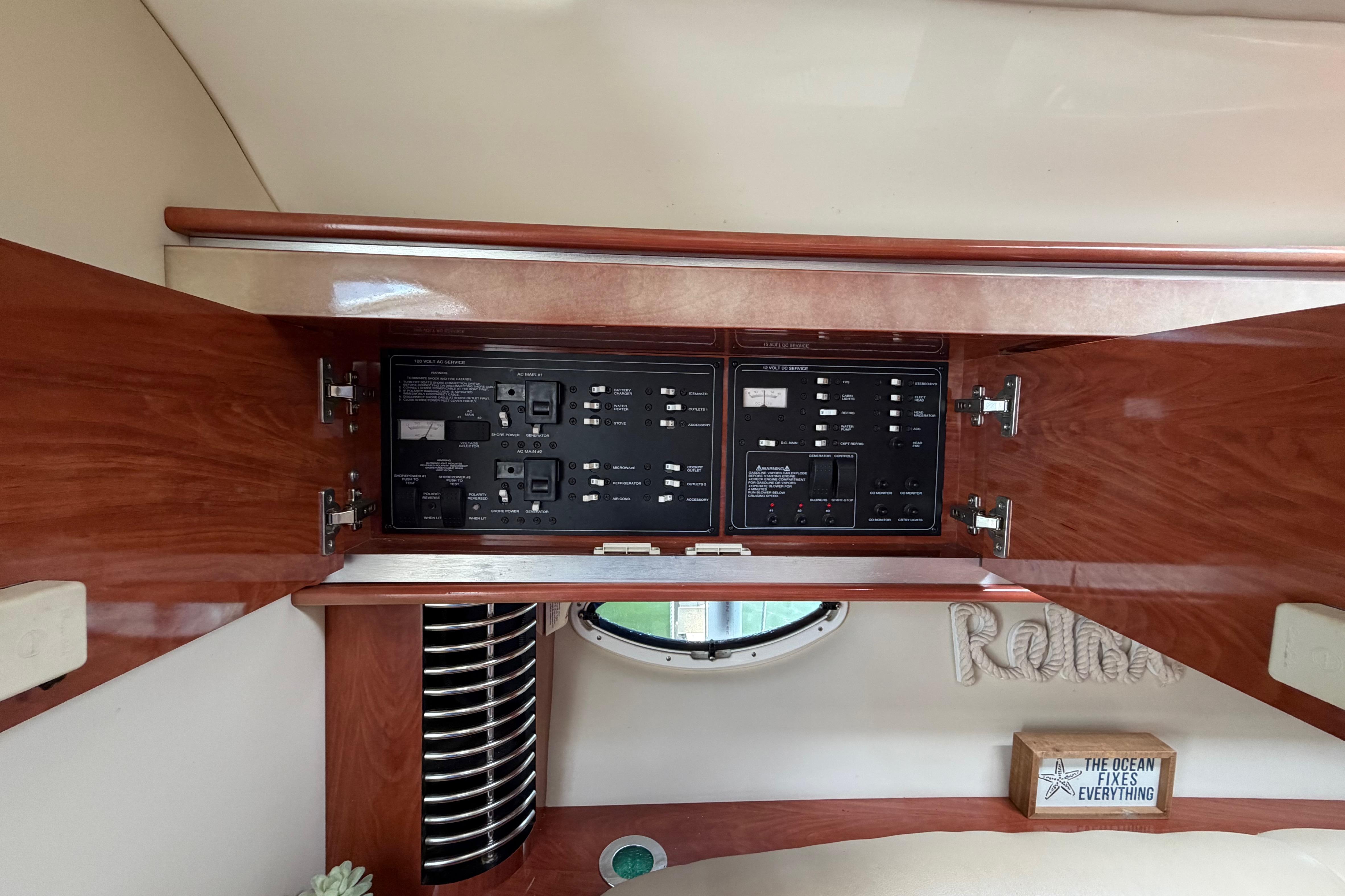 Electrical panel inside 2007 Monterey 350 Sport Yacht with wooden cabinetry and nautical decor.