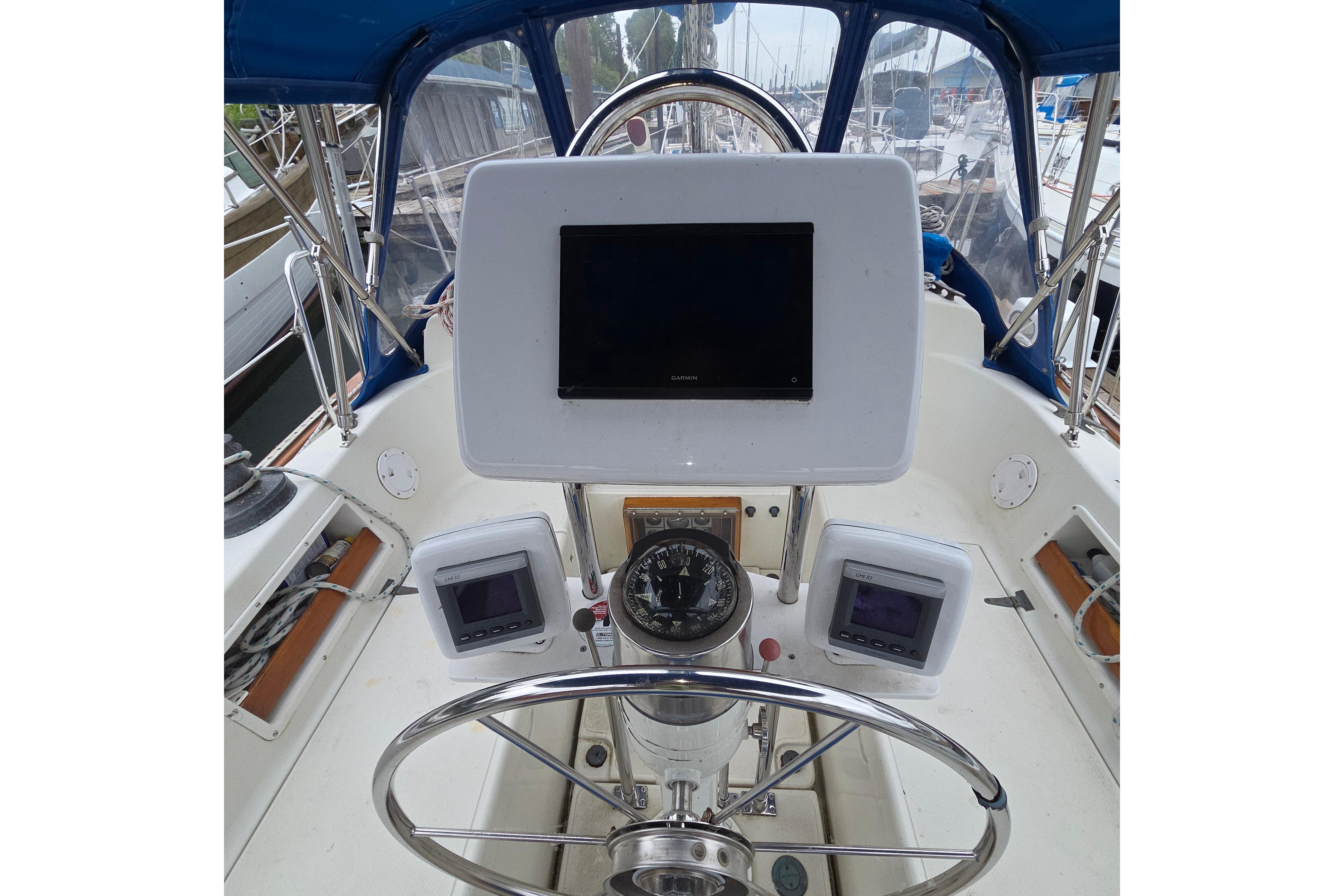 Cockpit of 1983 Pacific Seacraft 34 sailboat with navigation instruments and steering wheel.