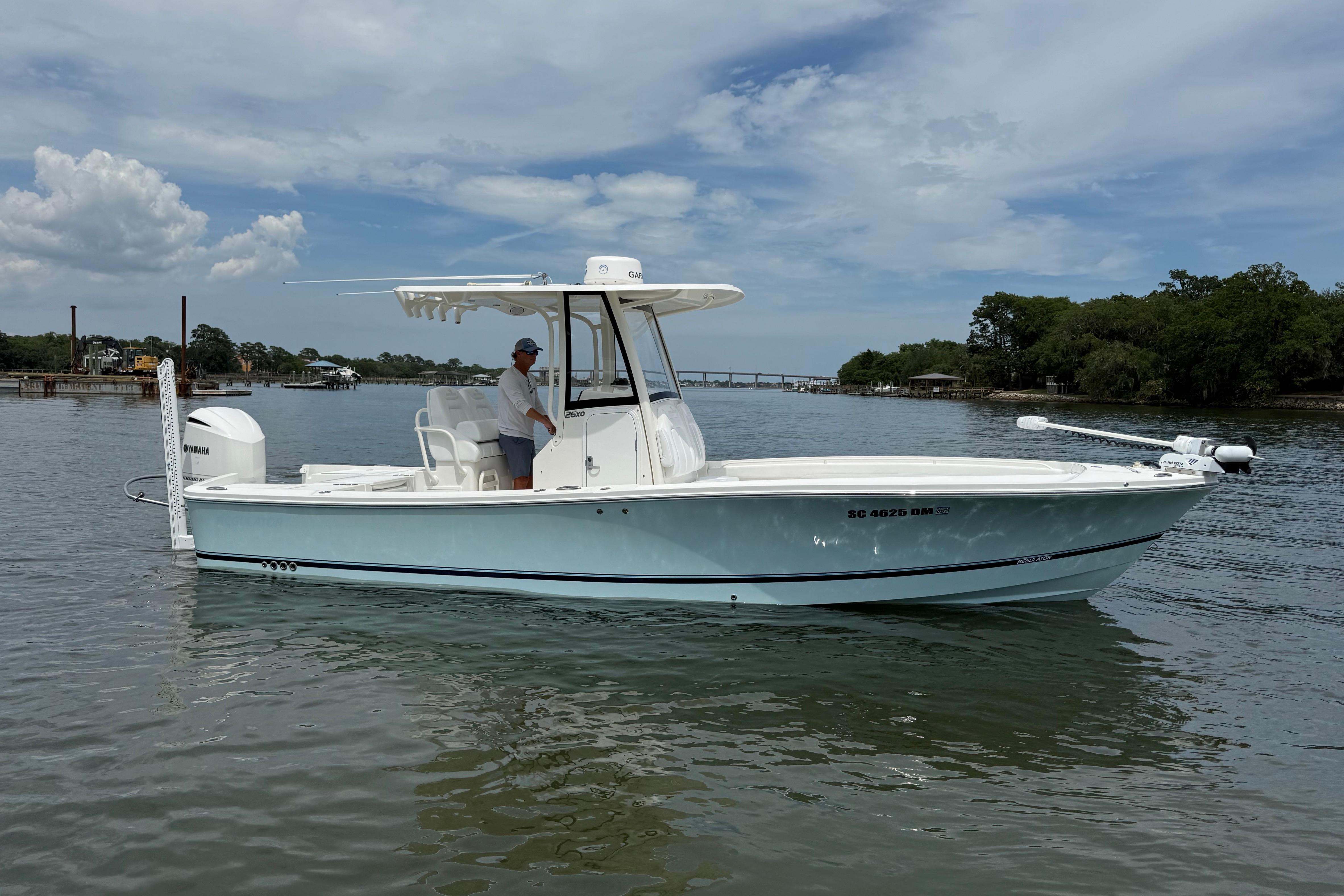 2019 Regulator 26XO boat on calm water under a partly cloudy sky.