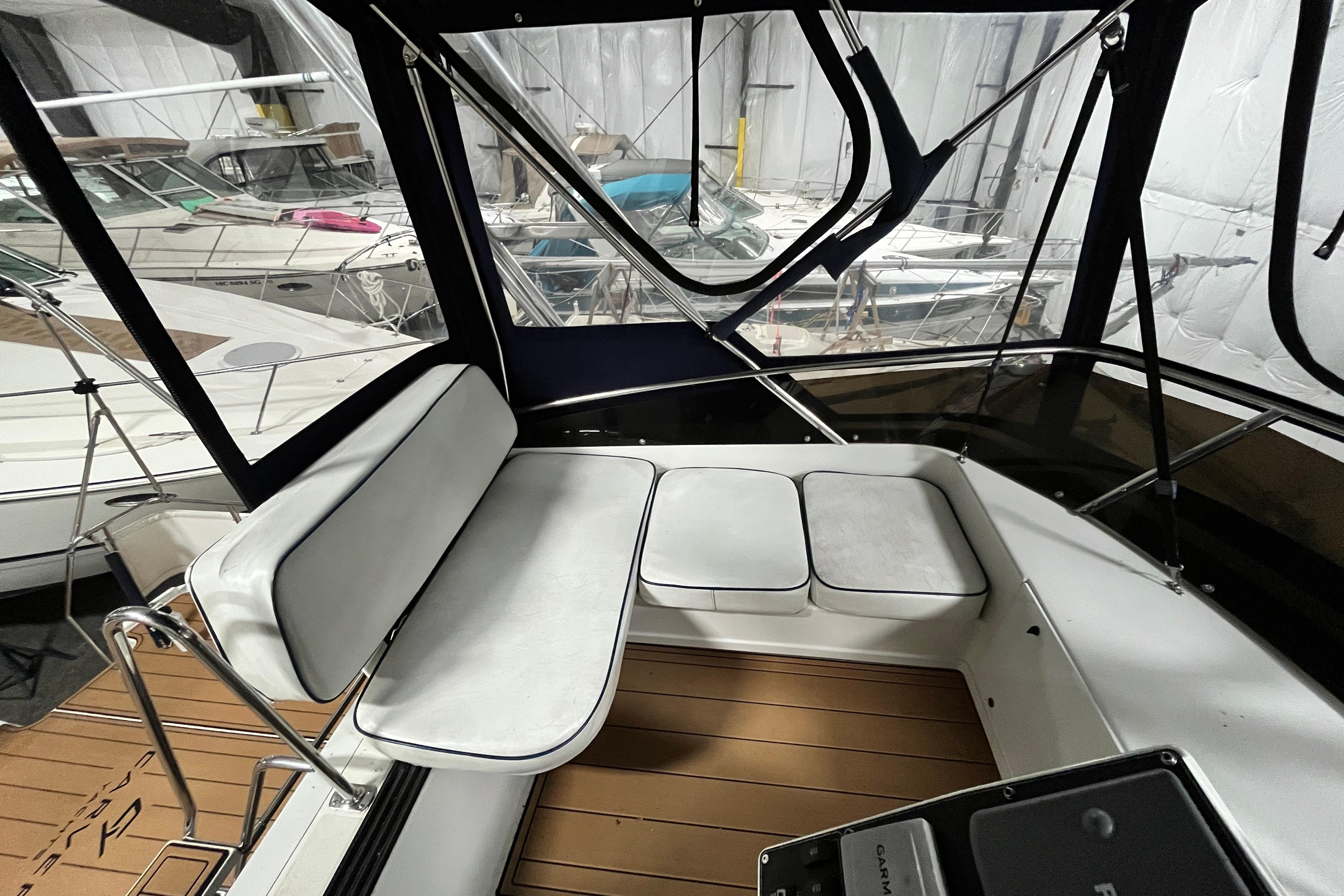 1995 Carver 325 Aft Cabin Motor Yacht interior with white seating and wood flooring.