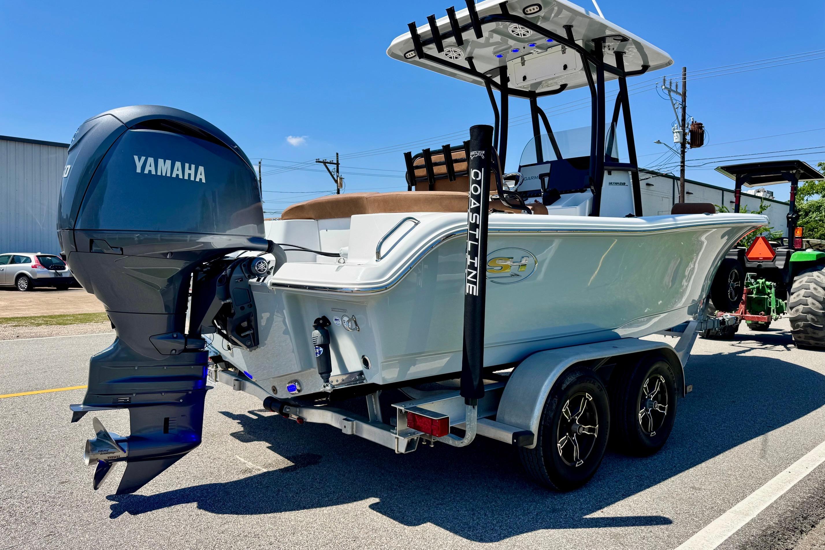 2025 Sea Hunt Ultra 219 boat with Yamaha engine on a trailer, parked outdoors.