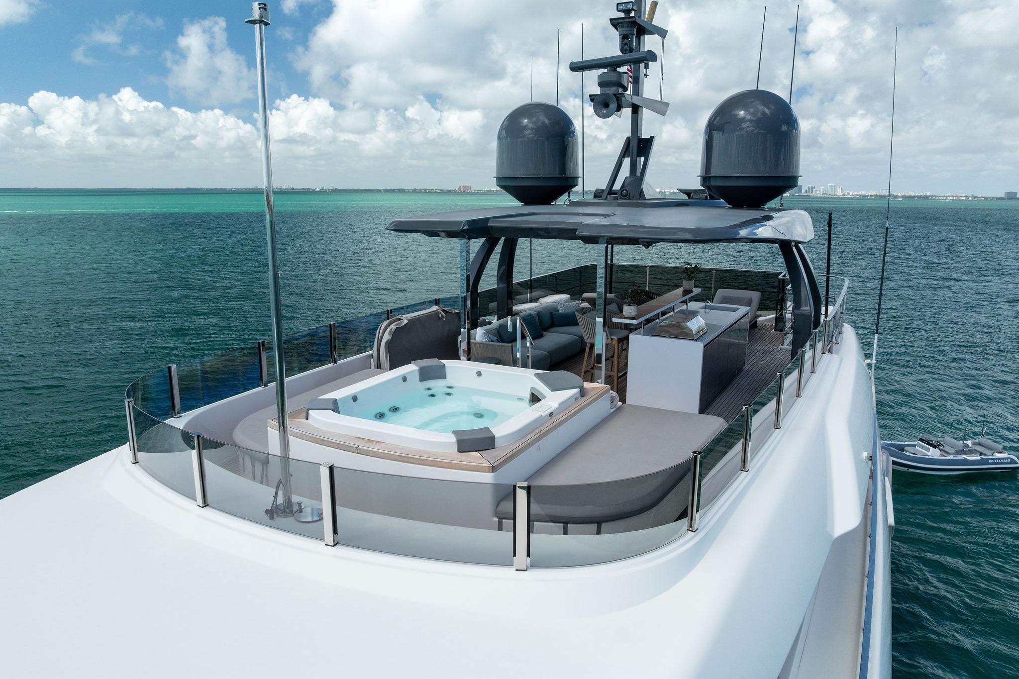 Luxurious 2023 Custom Line Navetta 33 yacht with jacuzzi on deck, cruising in clear waters.