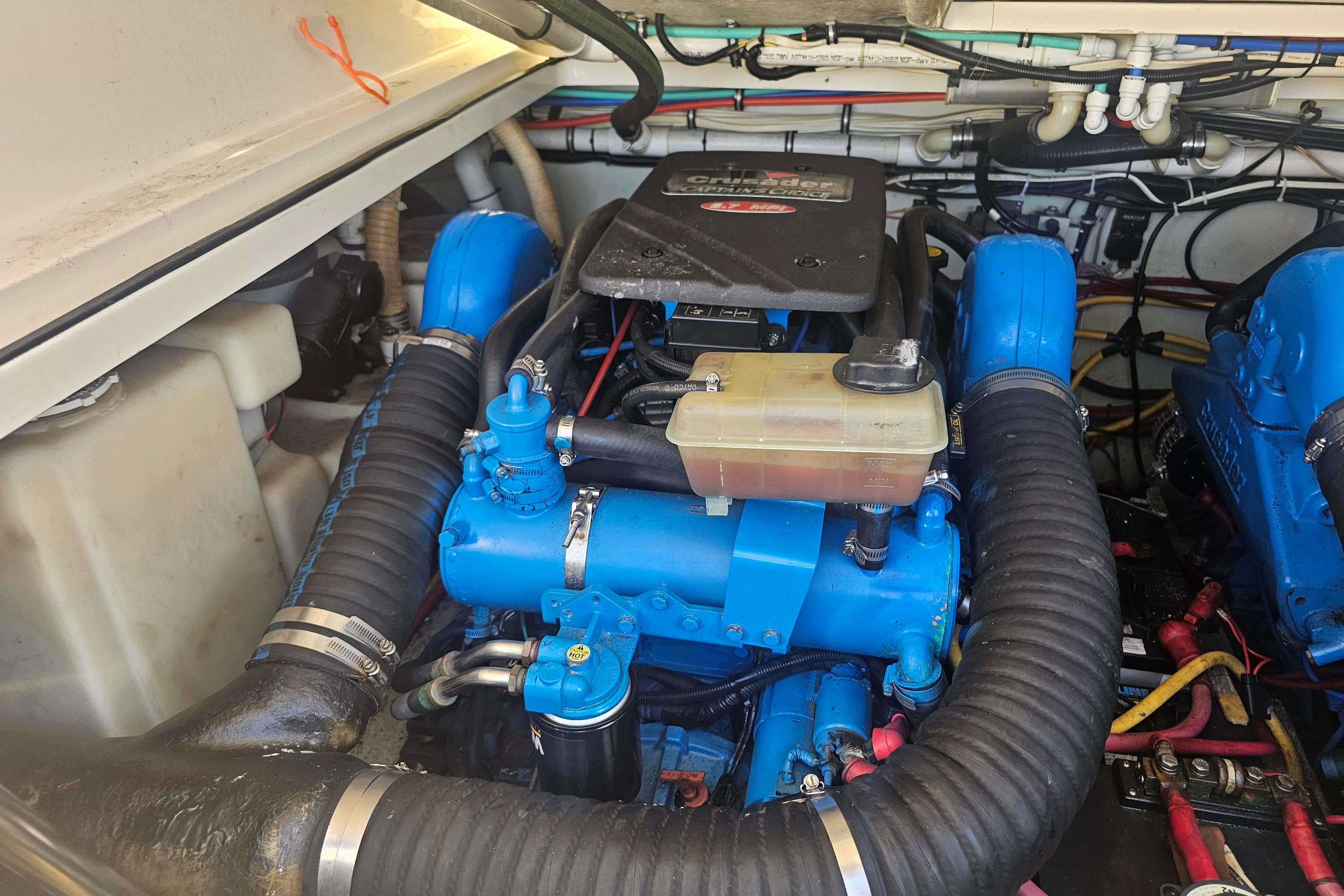 Engine compartment of a 2001 Pursuit 3000 Express boat, featuring blue components and hoses.