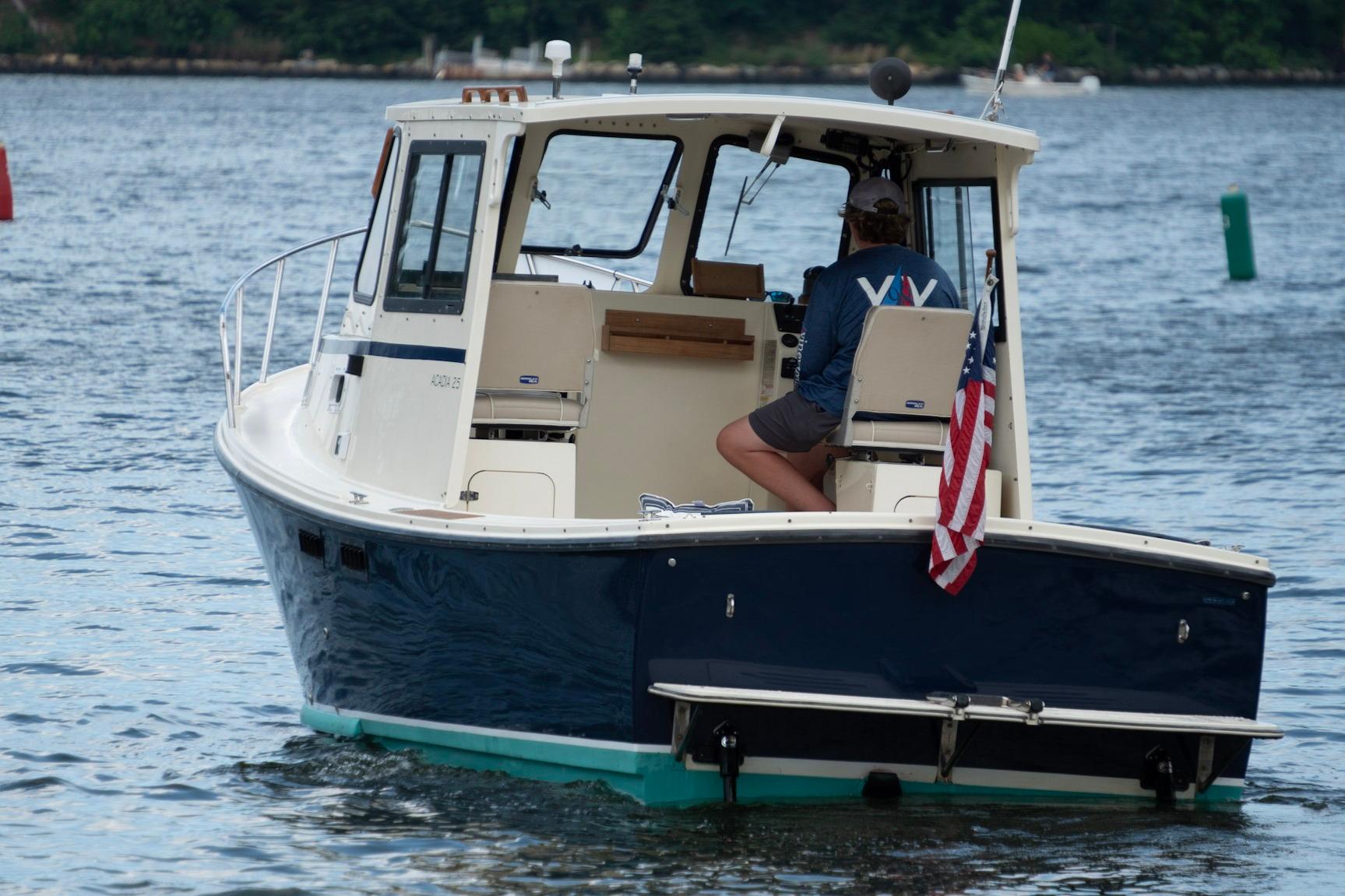 2006 Atlas Boat Works Acadia 25 cruising on water with American flag displayed.