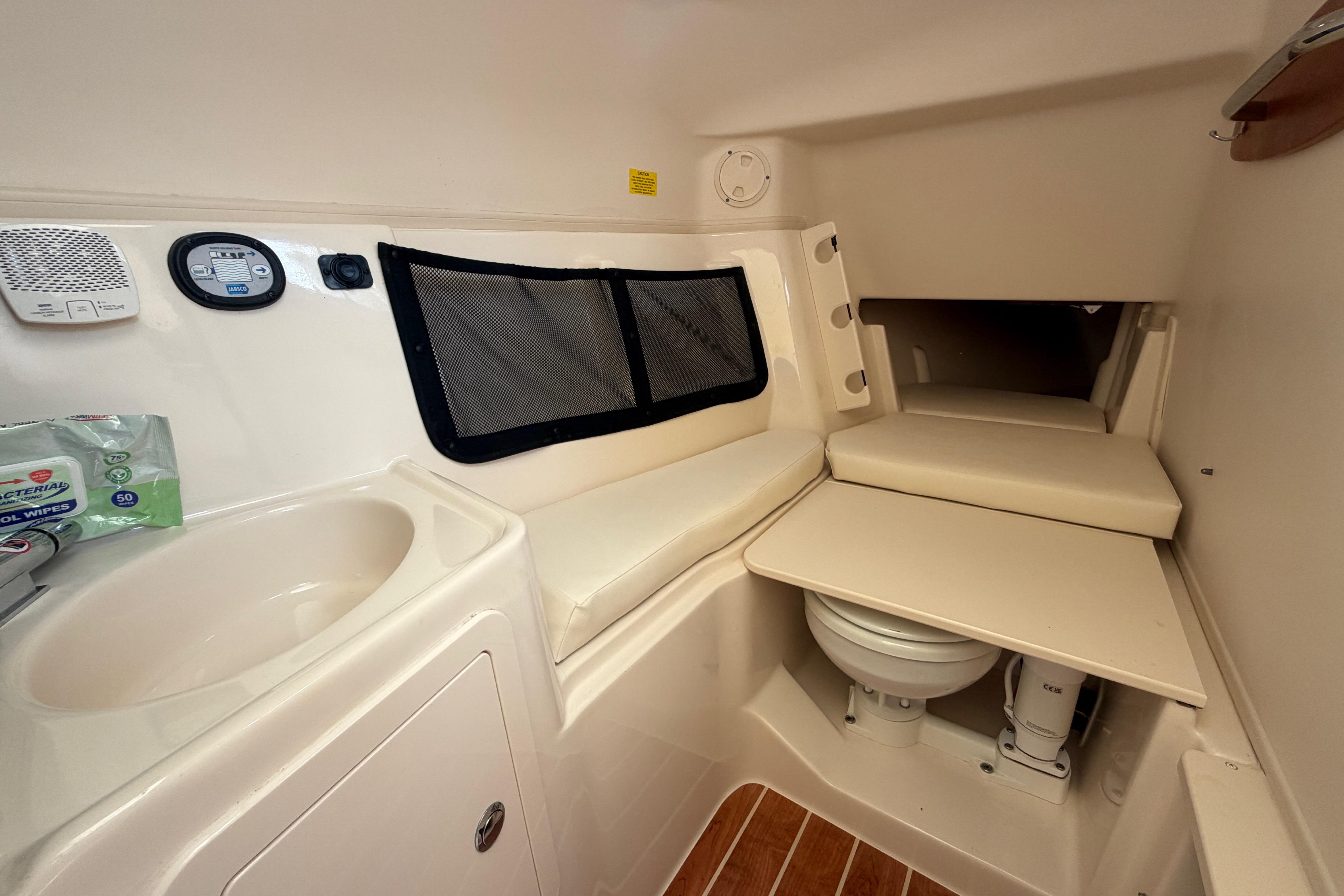 2019 Grady-White Freedom 307 boat interior with sink, toilet, and seating area.