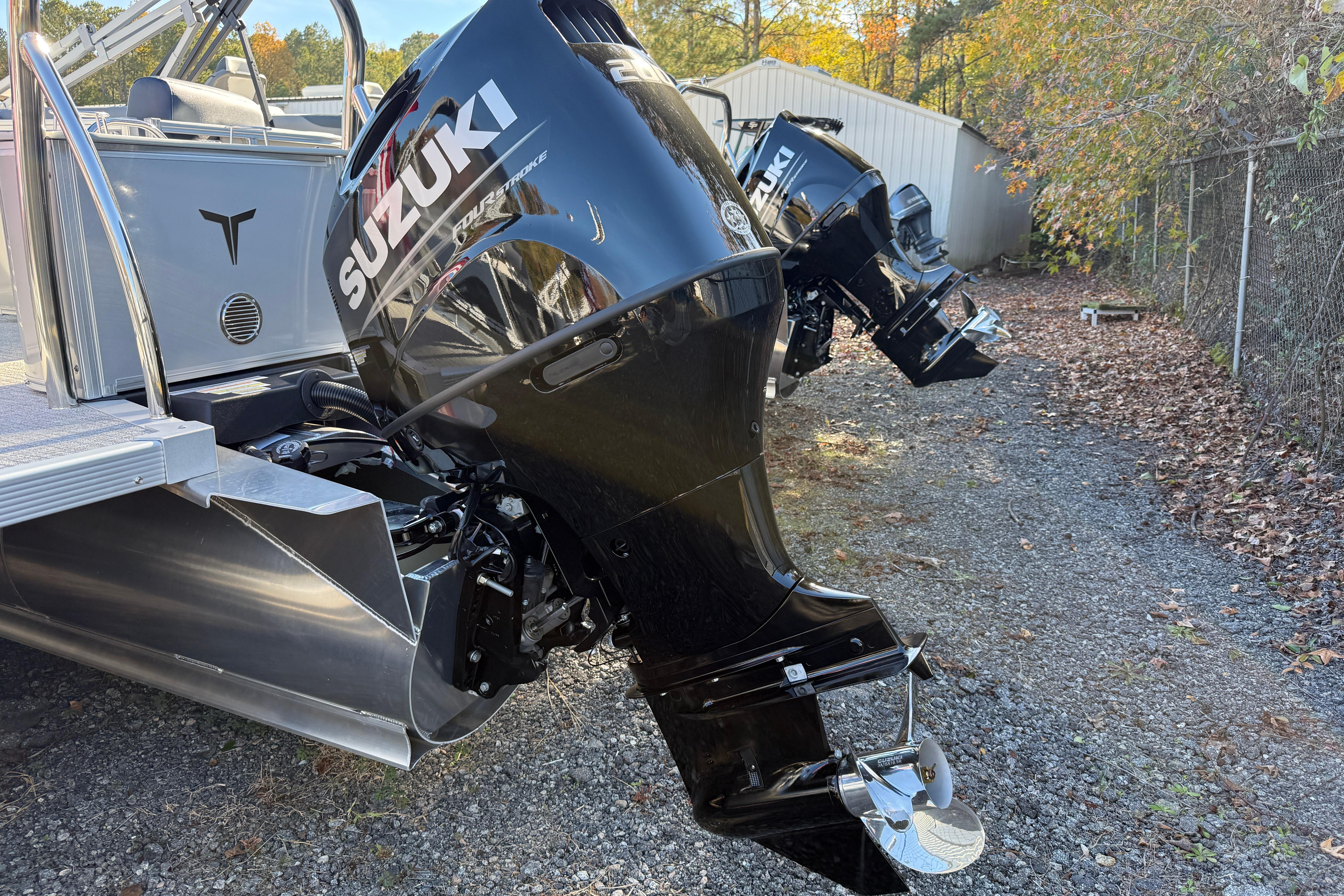 2026 Tahoe Pontoon LTZ Quad Lounger with Suzuki outboard motors, parked outdoors.