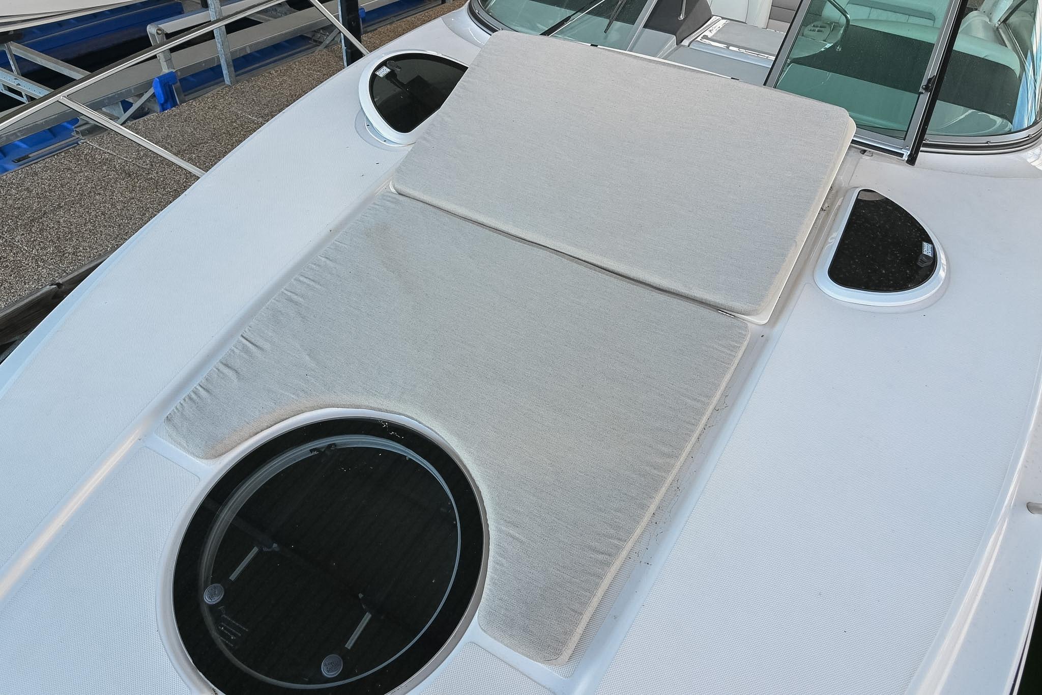 2021 Regal 33 Express boat deck with cushioned sunbathing area and circular hatch.