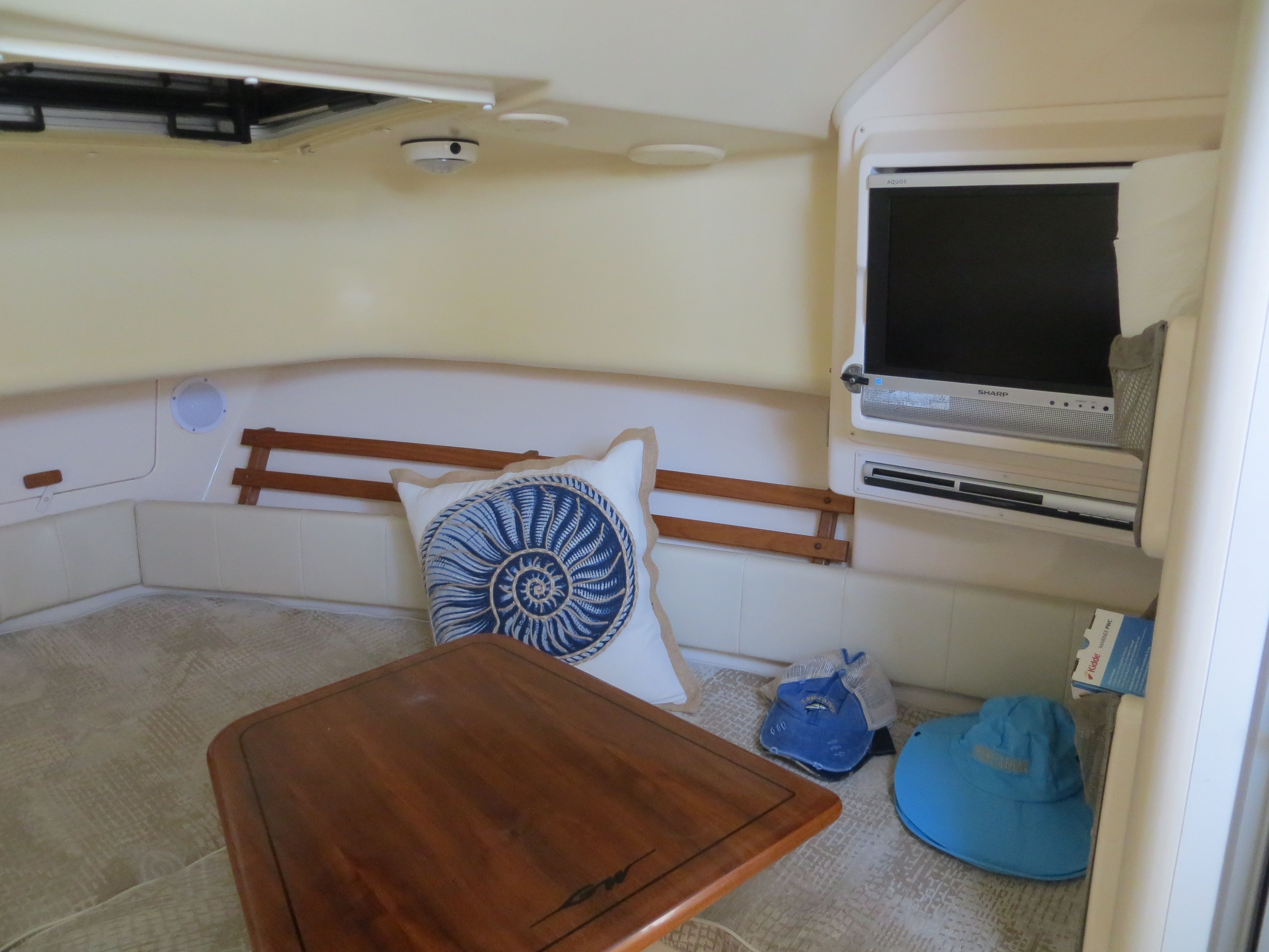 Interior of a 2007 Grady-White Sailfish 282 with table, cushion, and TV.