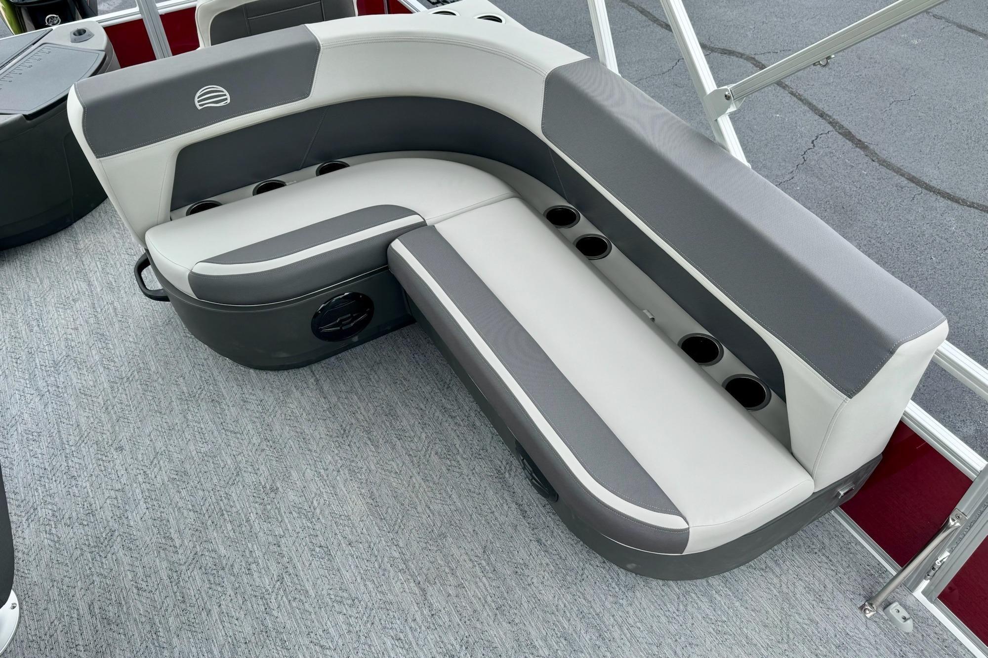 2026 Sun Tracker Bass Buggy 18 DLX pontoon boat seating with cup holders, gray and white upholstery.