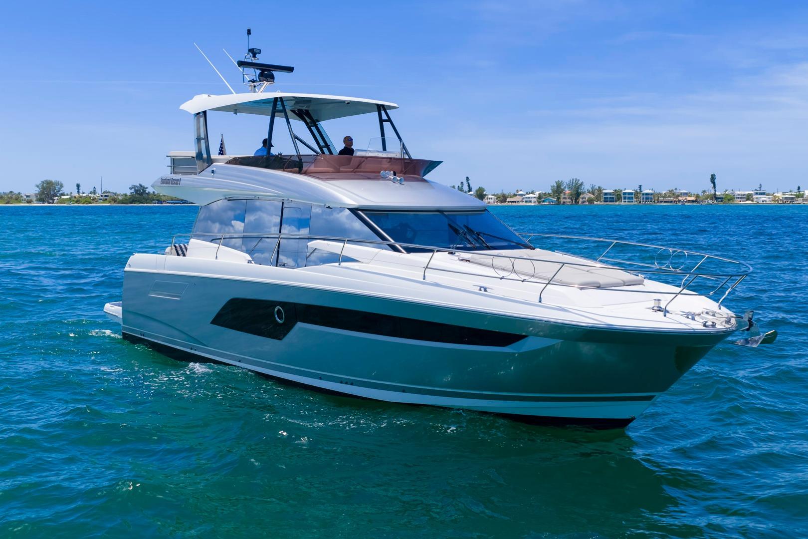 Luxury 2022 Prestige 520 yacht cruising on clear blue waters.