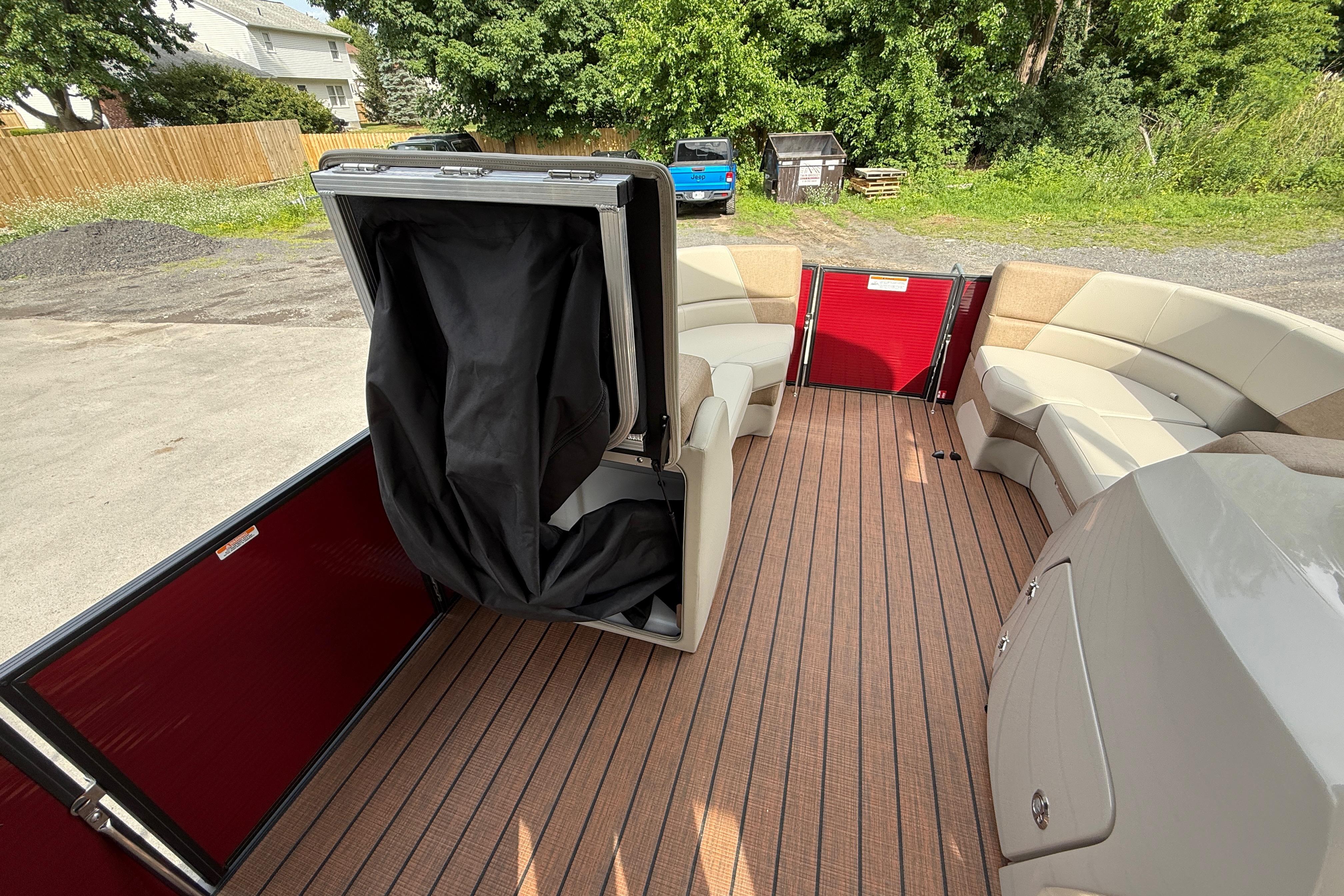 2027 Manitou 21 Aurora LE pontoon boat interior with seating and storage compartment.