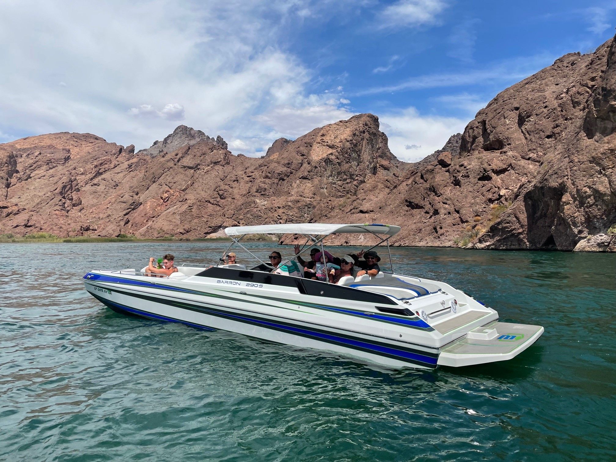 Custom Barron 290s boat 2021 on a lake with rocky background.