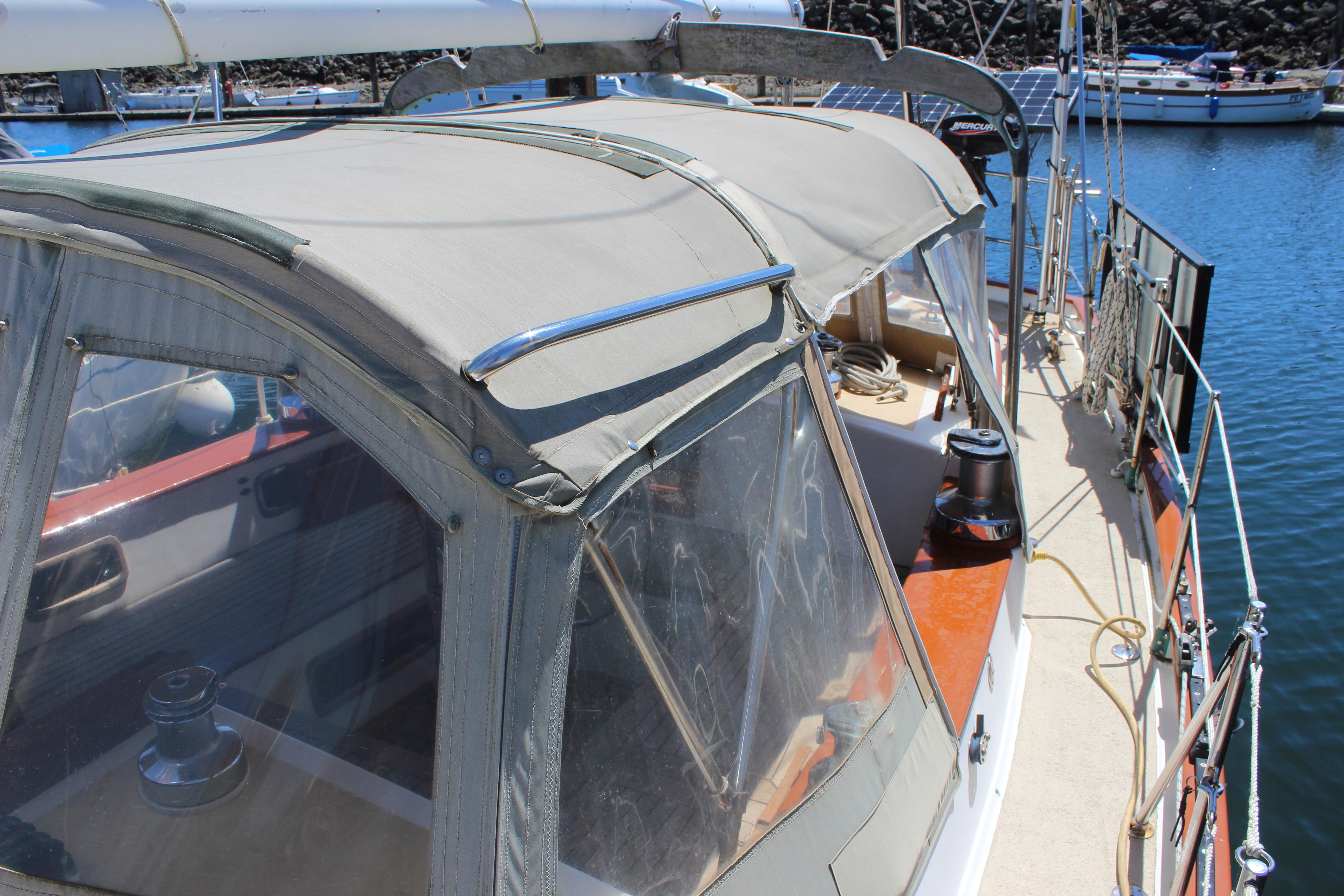 1981 Kelly Peterson 46 sailboat with covered cockpit, docked in a marina.