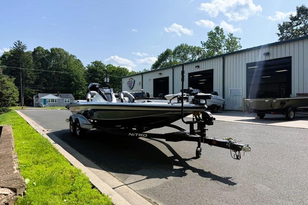2025 Nitro Z21 XL Pro boat on trailer outside a warehouse on a sunny day.