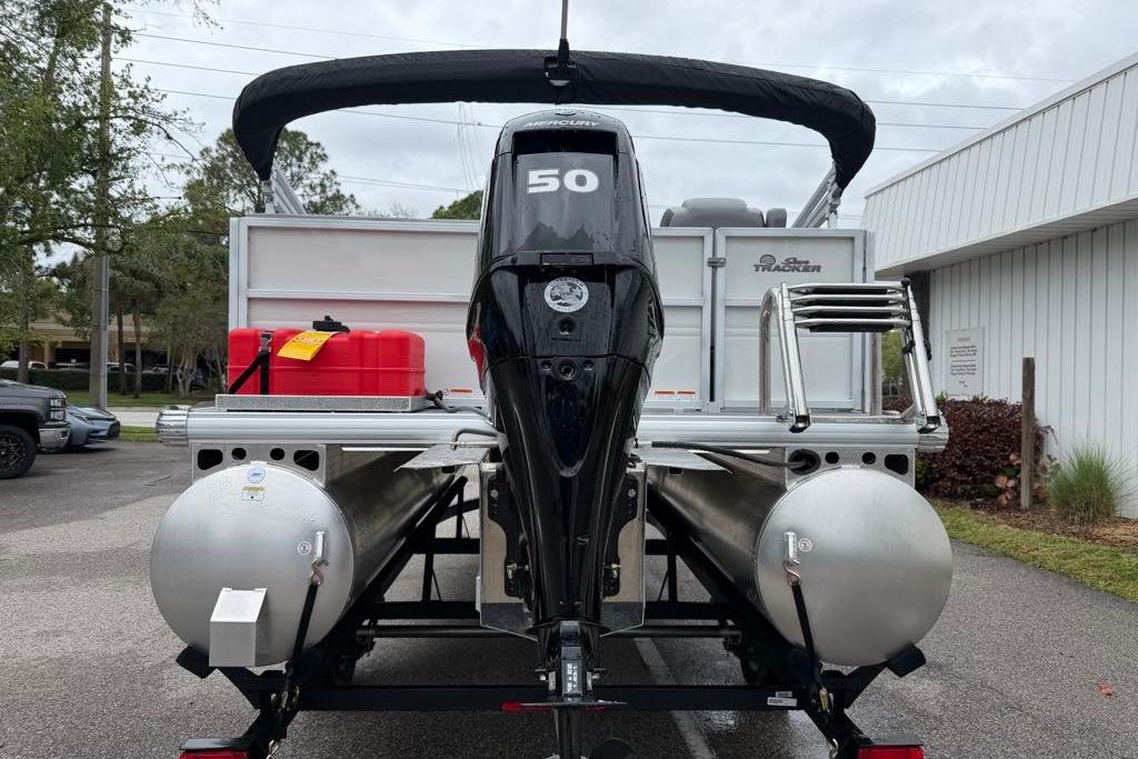2026 Sun Tracker Party Barge 16 DLX pontoon boat with outboard motor, parked outdoors.