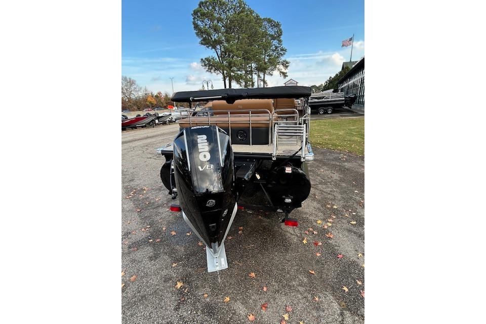 2025 Regency 230 LE3 Sport boat with powerful Mercury V8 engine, parked outdoors.