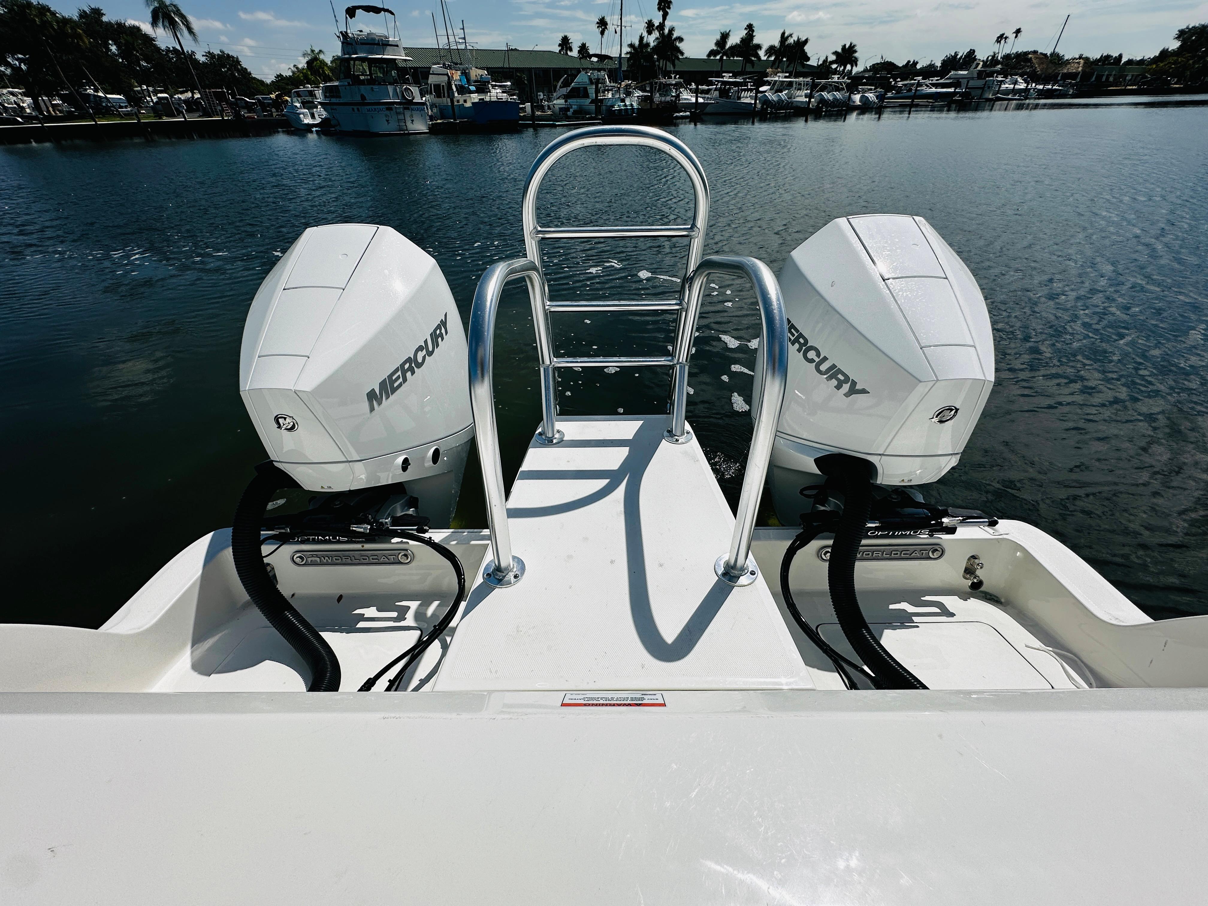 2024 World Cat 260 CC-X boat with twin Mercury engines on a calm marina.