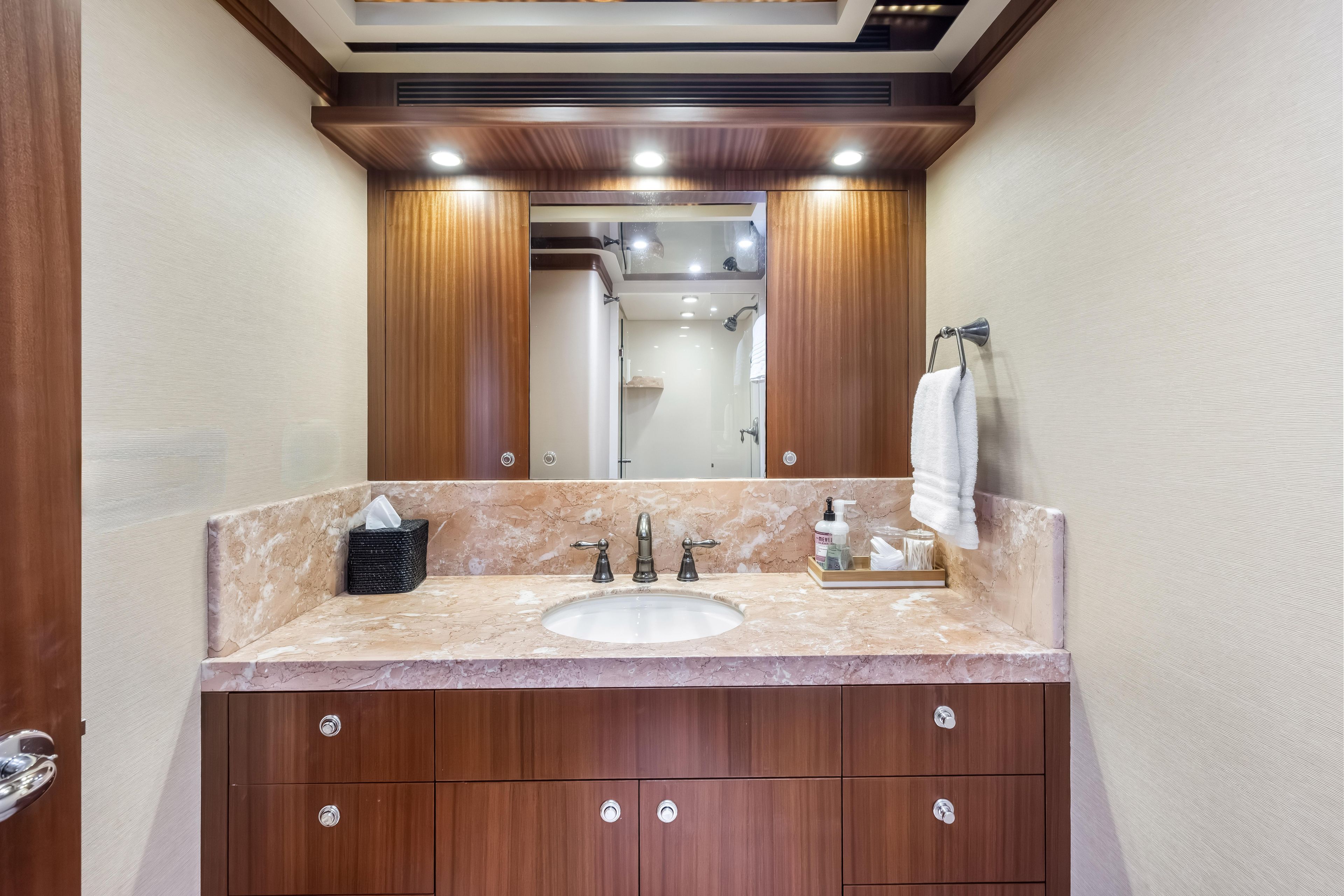 Luxurious bathroom interior on 2012 Cheoy Lee 84 Bravo yacht, featuring marble countertop and wooden cabinetry.