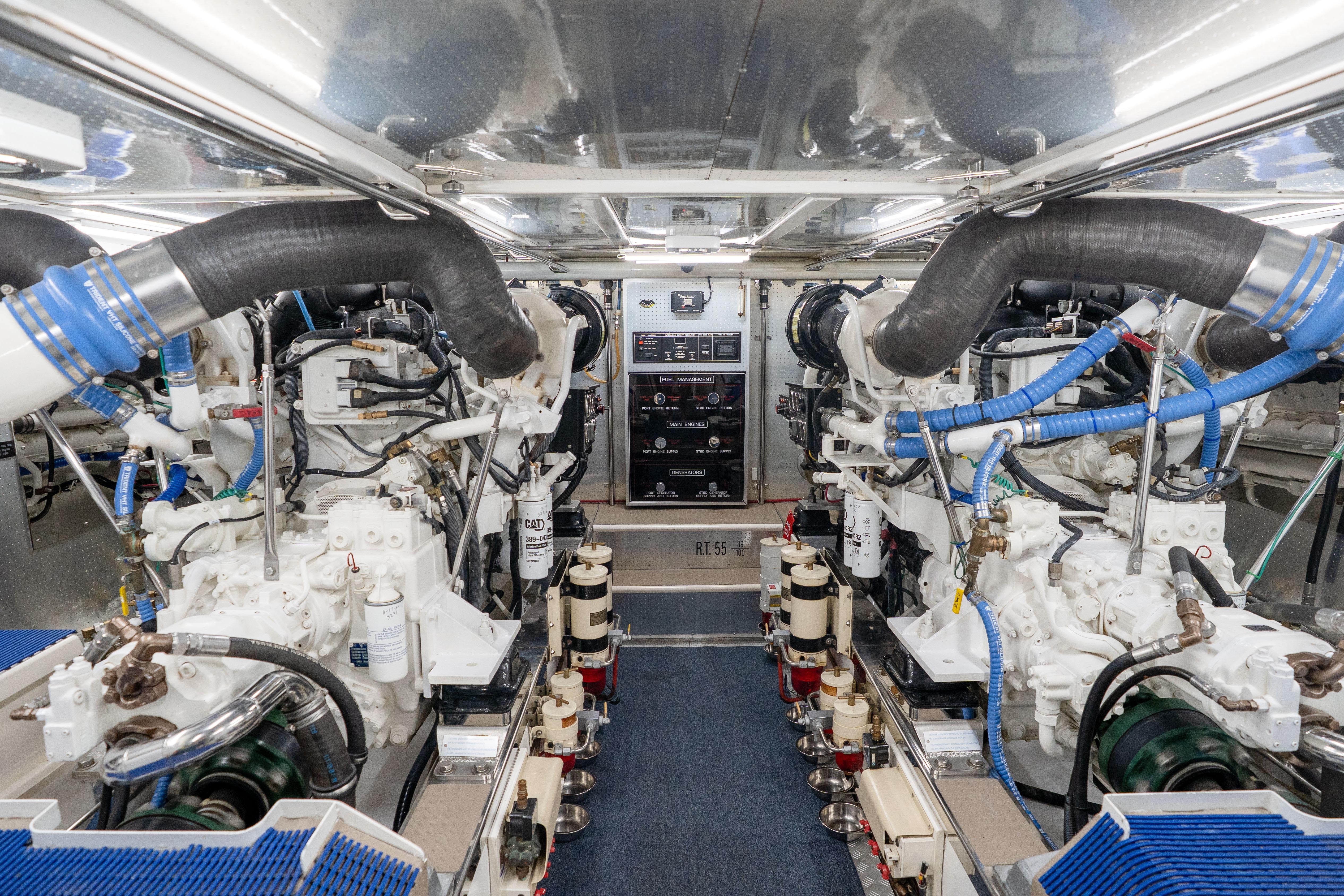 Engine room of a 2006 Fleming 75 yacht, showcasing dual engines and complex piping.