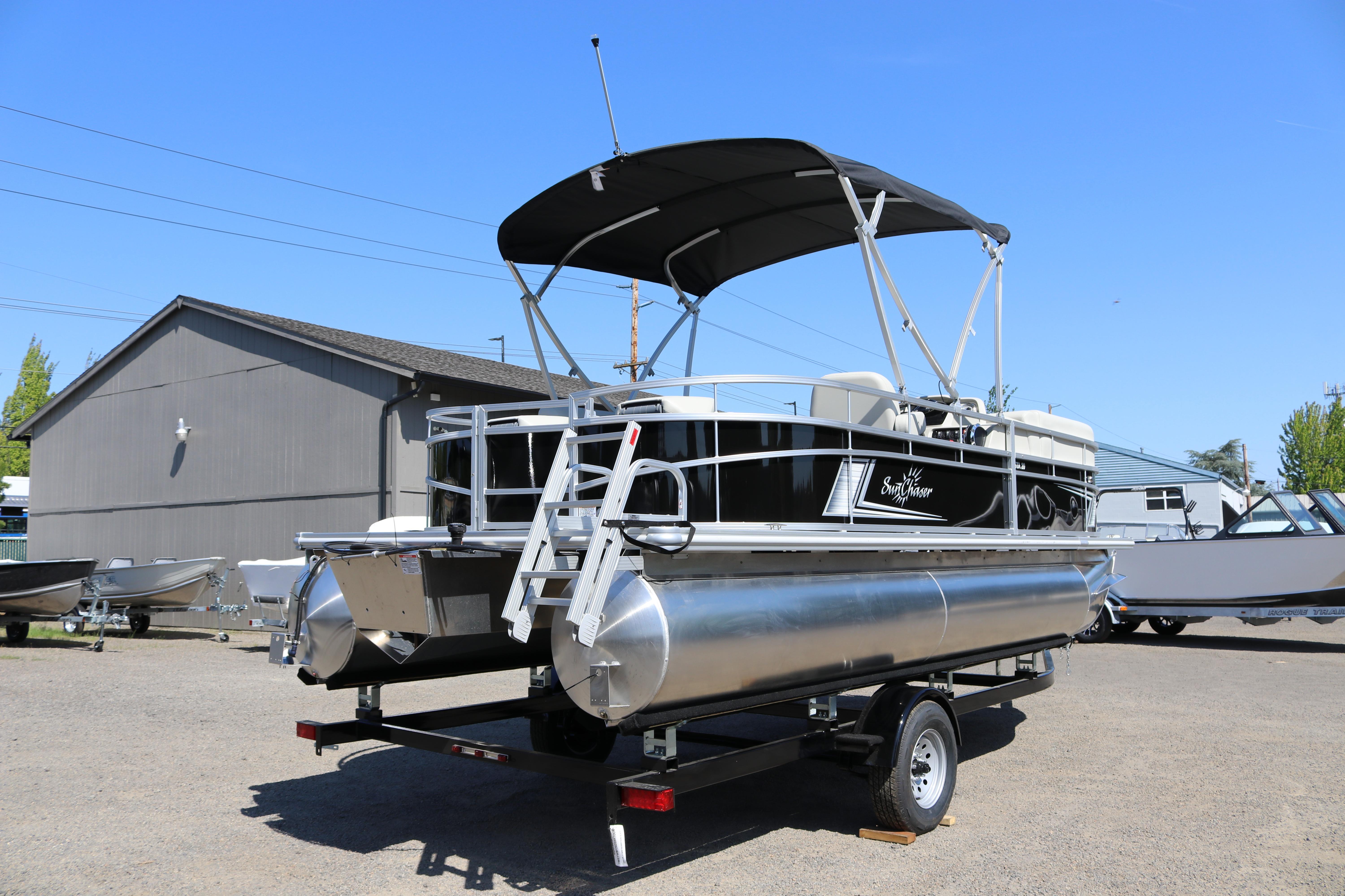 2025 SunChaser Vista 20 Fish pontoon boat on trailer, parked outdoors under clear blue sky.