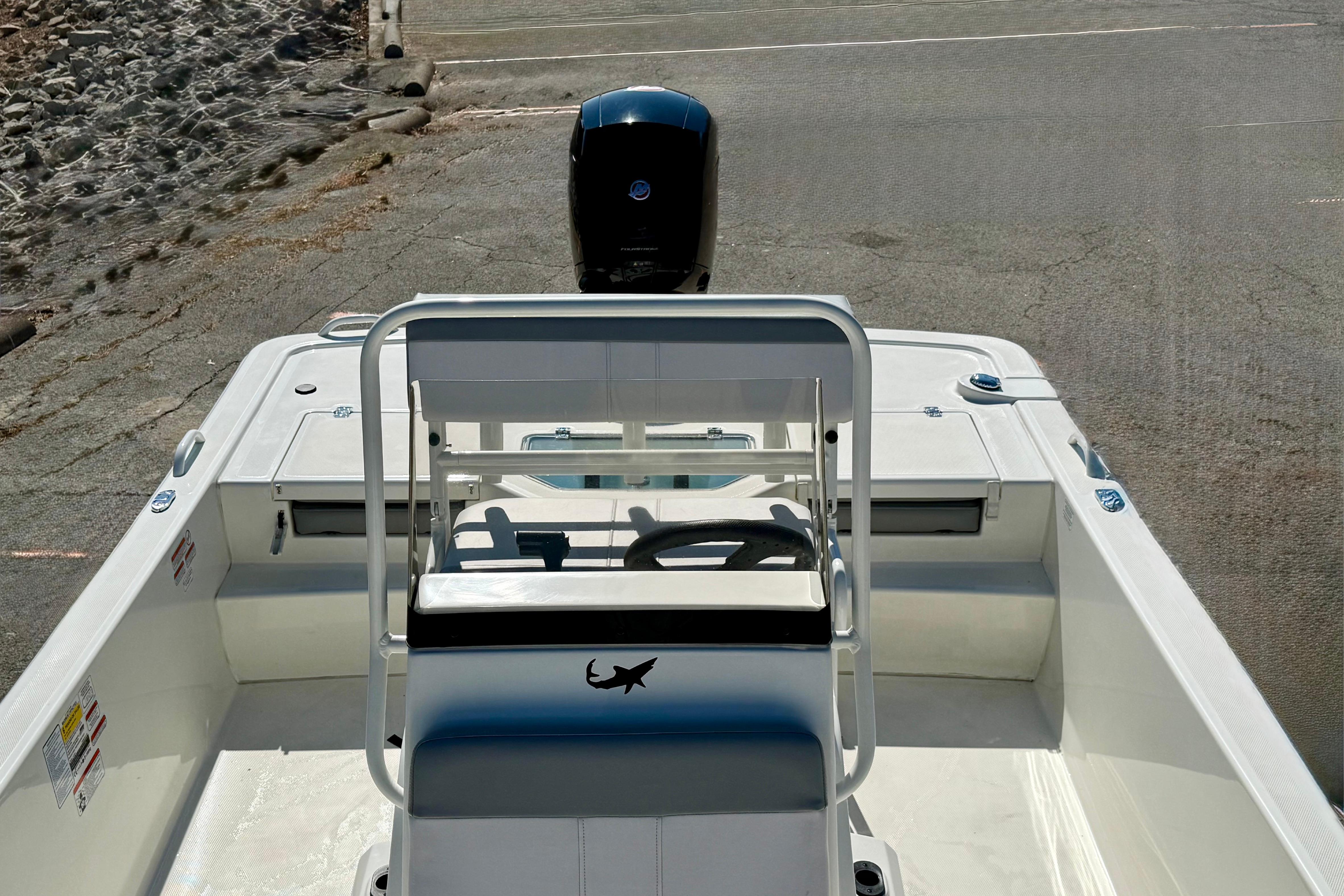 2024 Mako Pro Skiff 19 CC boat interior with steering console and outboard motor.