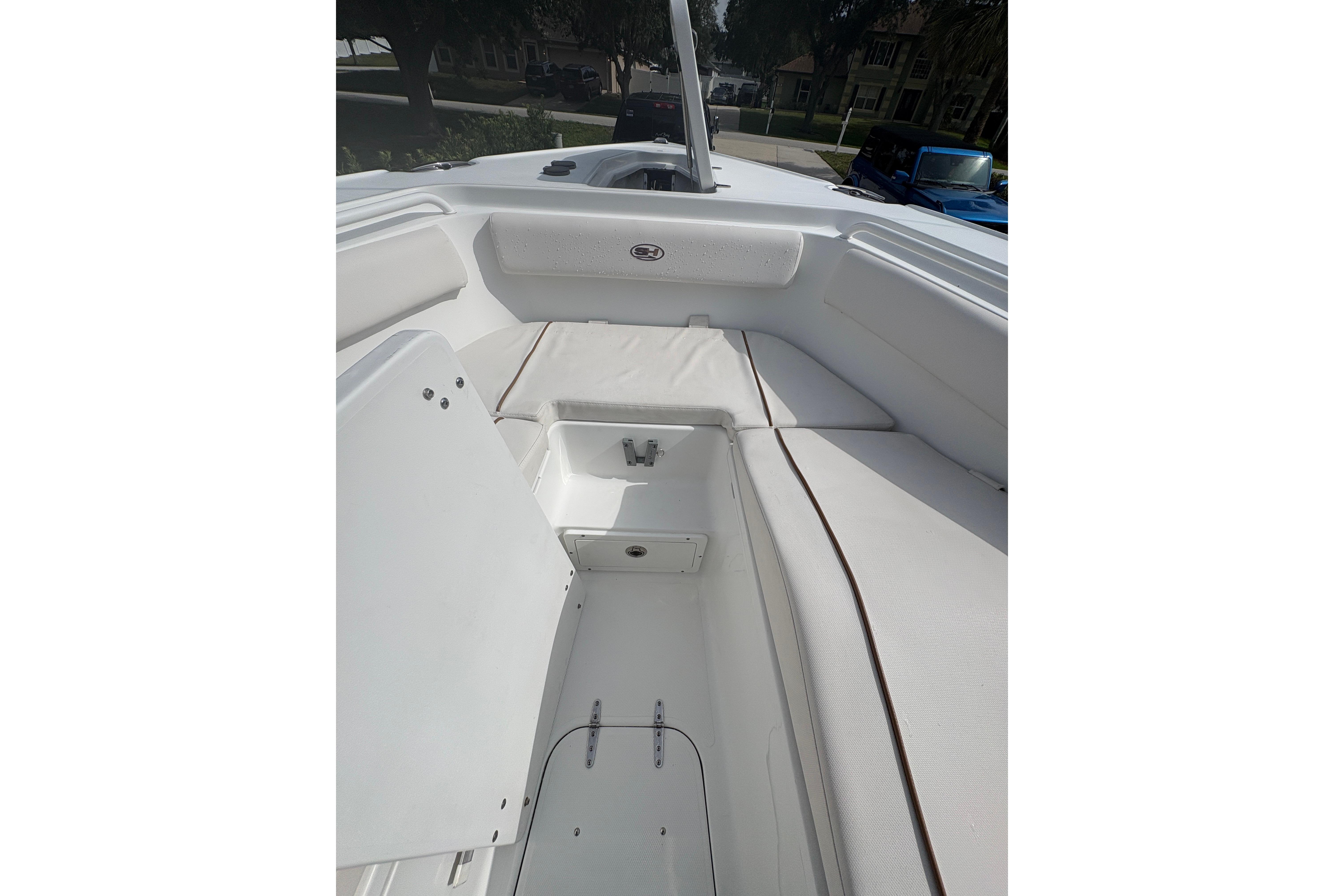 2021 Sea Hunt Ultra 265 SE boat interior with white seating and storage compartments.
