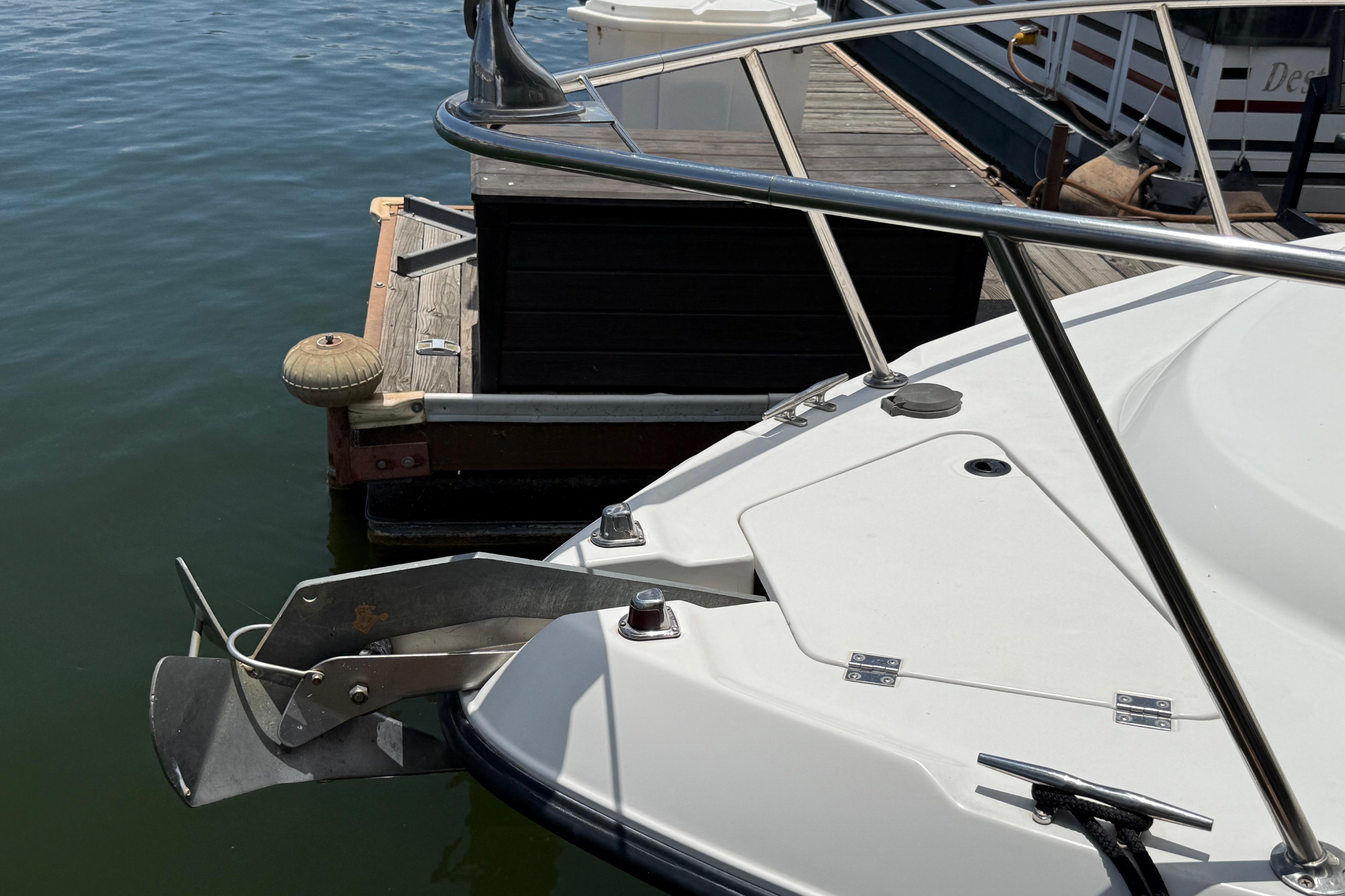 1999 Chaparral Signature 300 boat docked, showing anchor and deck details.