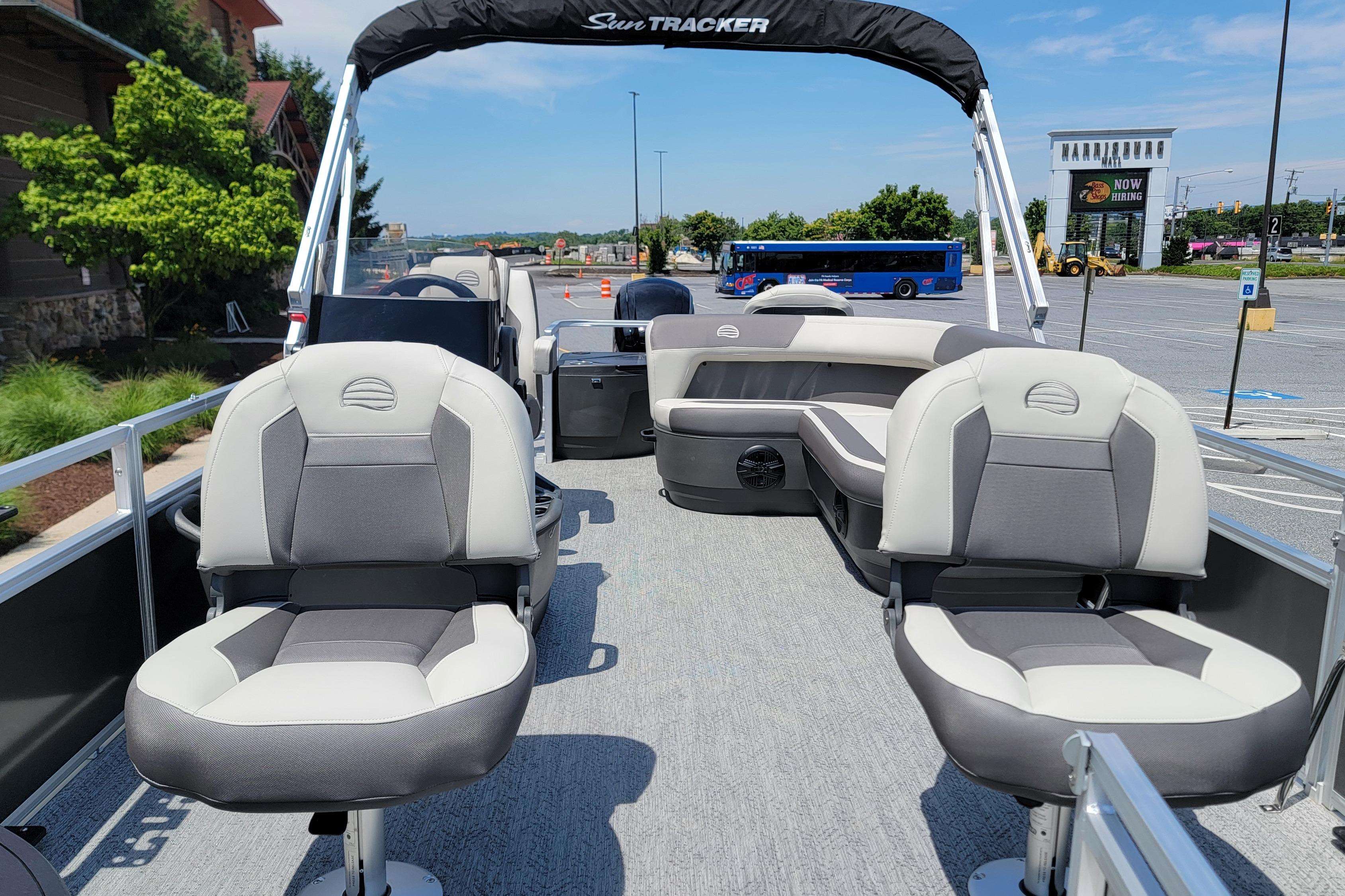 2026 Sun Tracker Bass Buggy 18 DLX pontoon boat with comfortable seating in a parking lot.