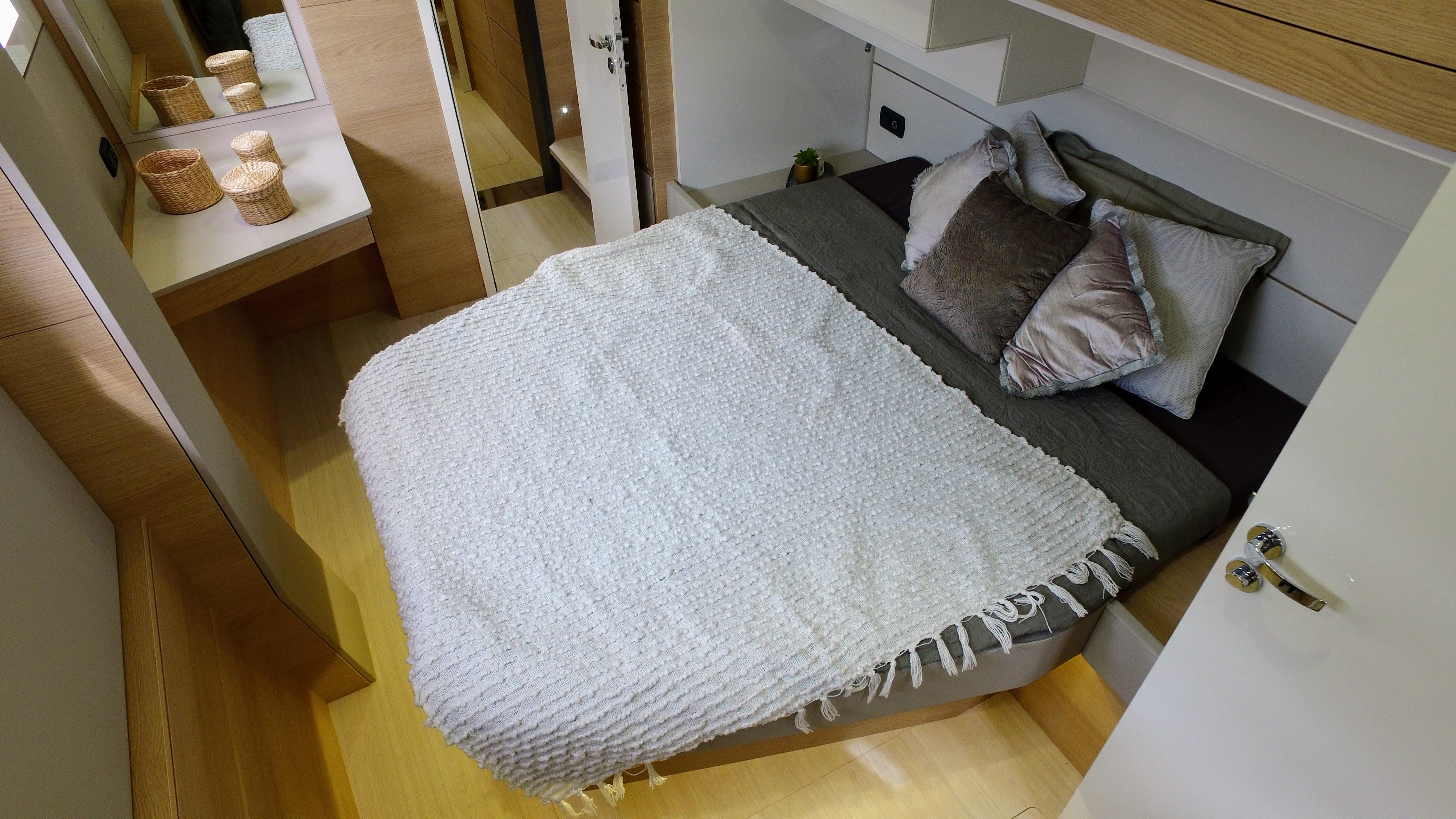 Cozy bedroom in 2025 Aventura 45 yacht with modern decor and comfortable bedding.