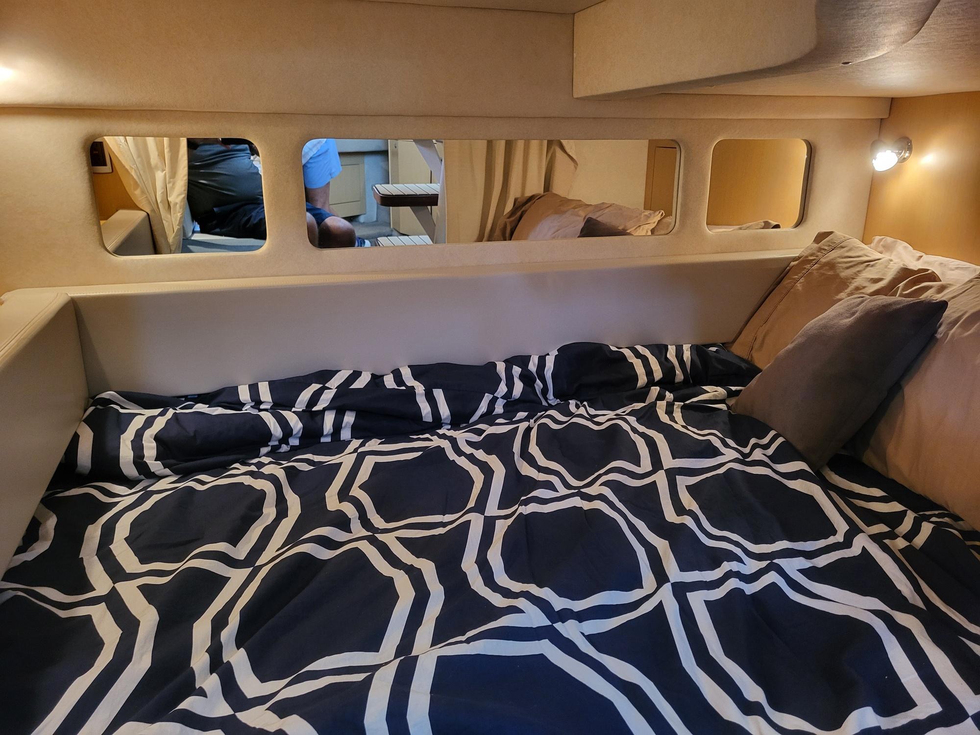 2009 Sea Ray 310 Sundancer cabin with patterned bedding and ambient lighting.