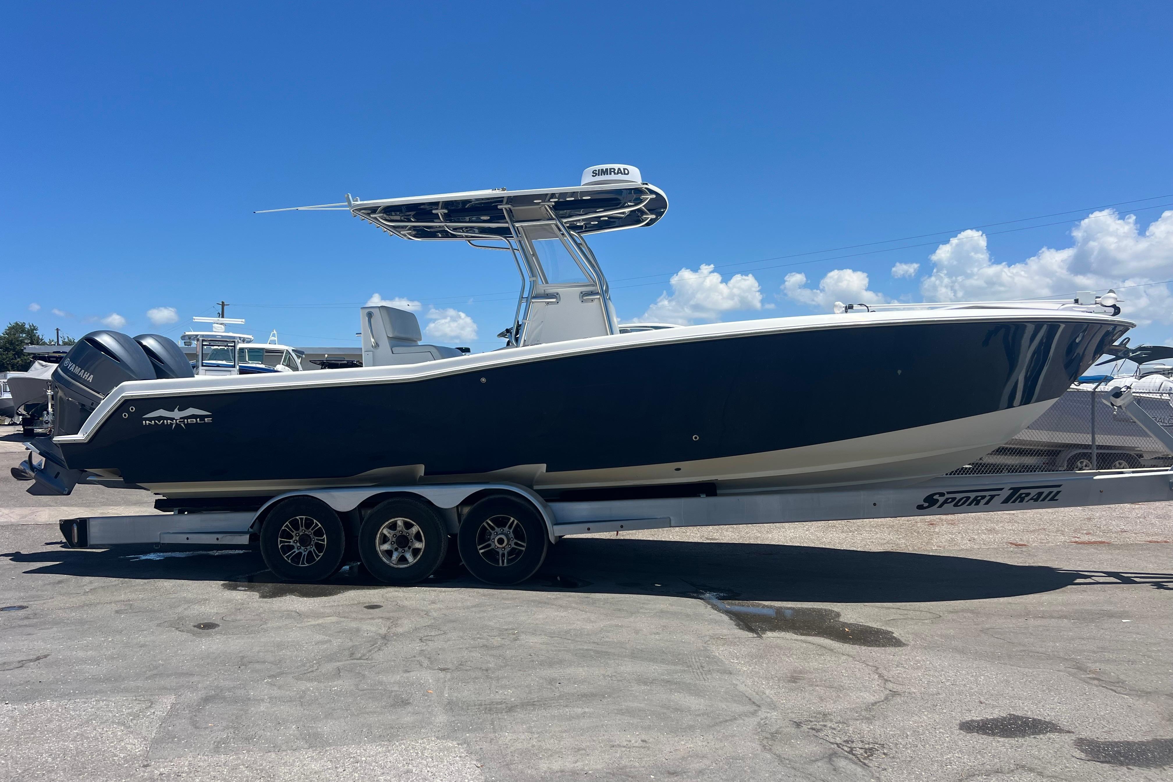 2012 Invincible 33 Open Fisherman boat on trailer under clear blue sky.