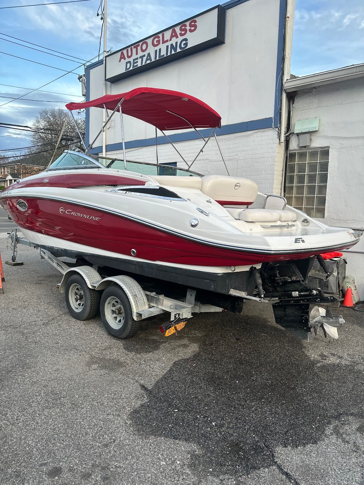 2014 Crownline Eclipse E2 boat on trailer outside auto glass shop.
