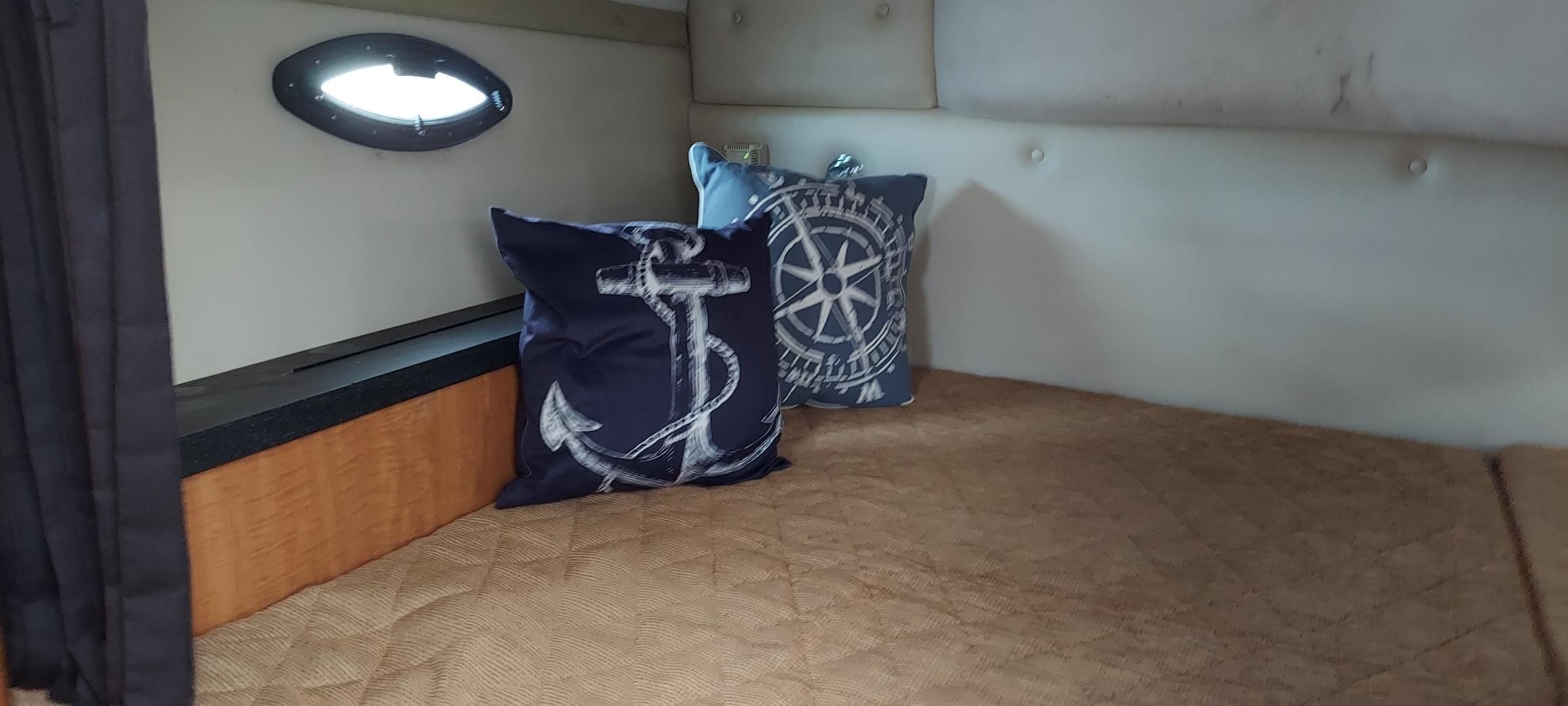 Interior of a Regal Commodore 2465 boat with nautical-themed pillows.