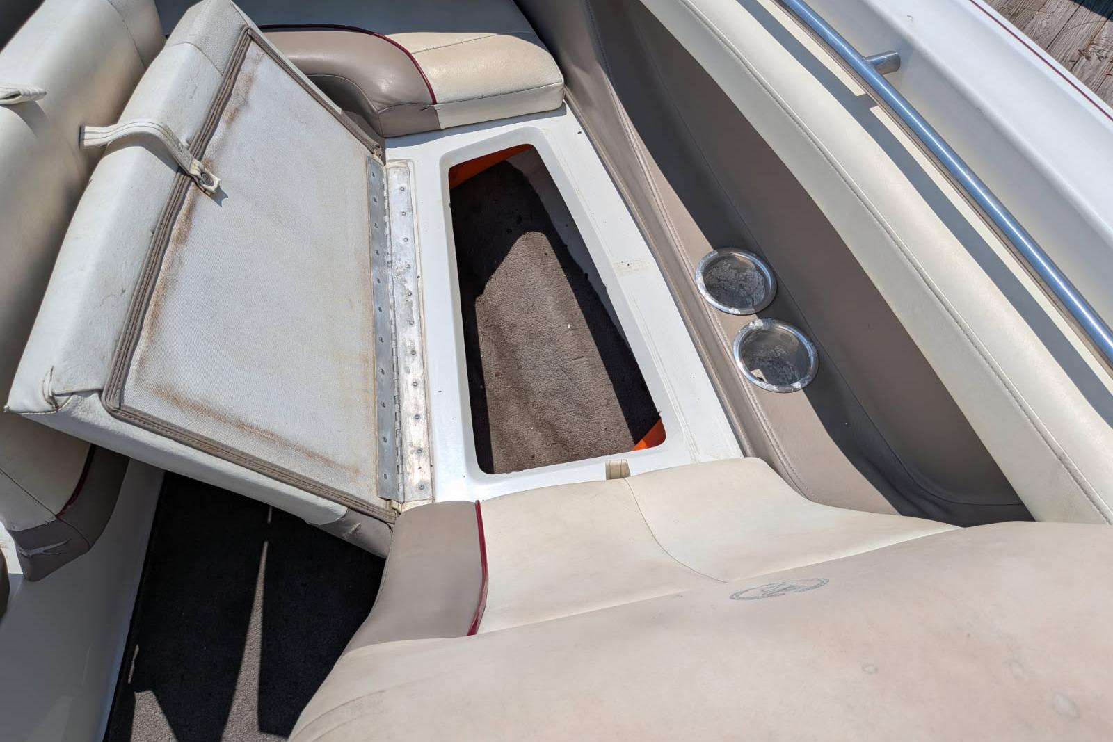 Open storage compartment in 2020 Cobalt 206 boat with beige seating and cup holders.