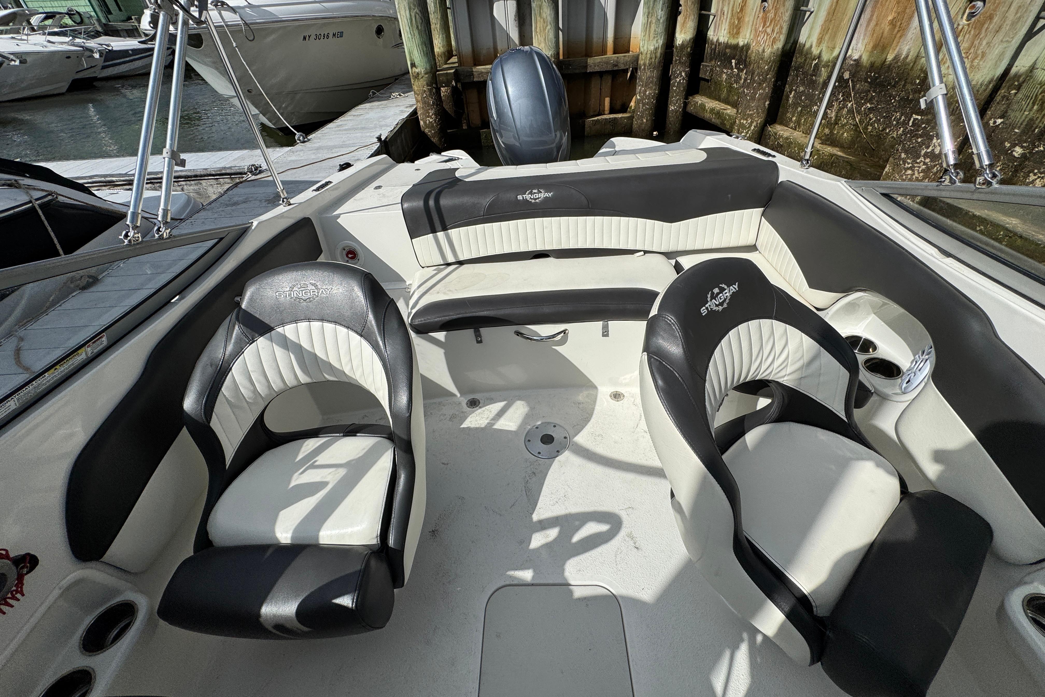 2019 Stingray 204 LR boat interior with black and white seating, docked at marina.