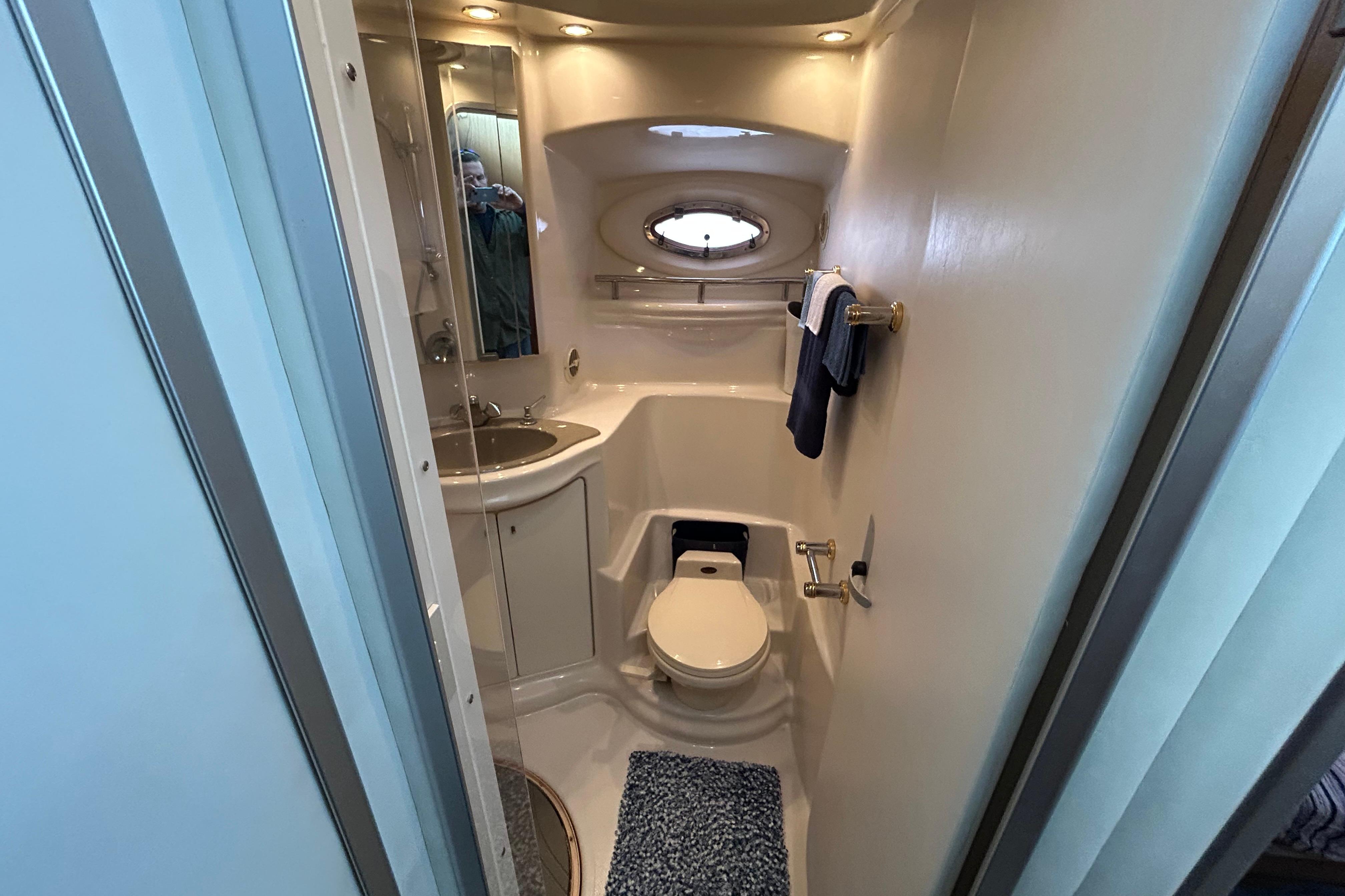 1999 Maxum 4600 SCB yacht bathroom with sink, toilet, and porthole window.